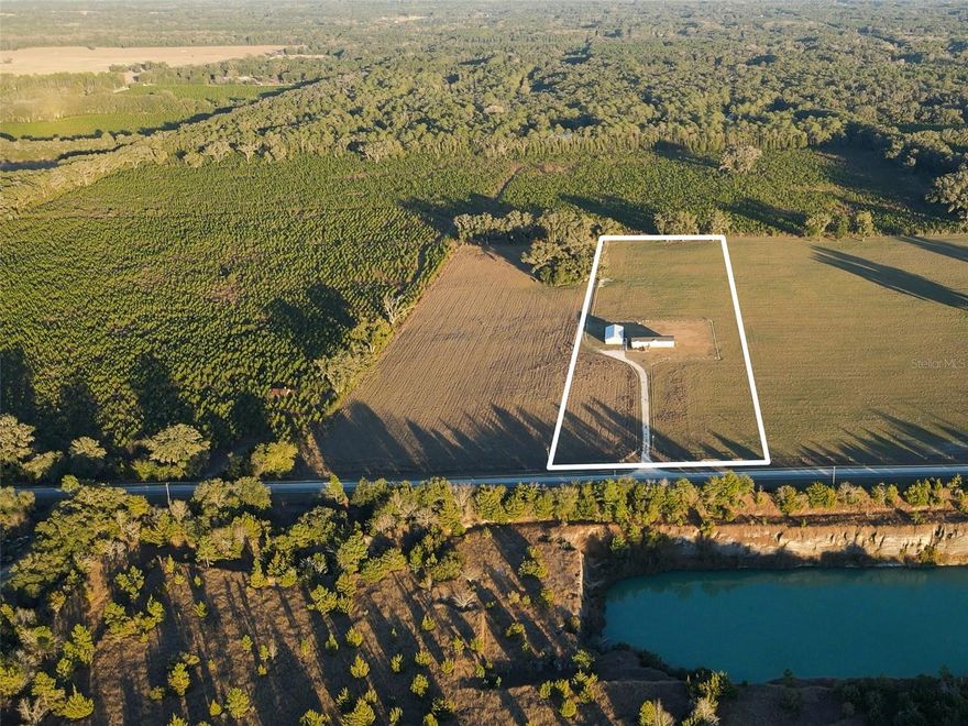 One or more photo(s) has been virtually staged. Have you ever dreamed of enjoying peace, privacy, and room to roam? This rare opportunity offers true homestead living on the border of Newberry and Jonesville—just minutes from all that Gainesville has to offer, yet far enough to experience the serenity of the countryside.
Welcome to Quarry Fields, a small subdivision featuring four 10 acre parcels, located just 2.4 miles off Newberry Road on NW 202nd St. This remarkable property provides unmatched privacy with no neighboring homes behind, beside, or across from you—only quiet, picturesque landscapes. A beautiful wrought iron gate welcomes you at the entrance. Travel down the long driveway to a spacious 2,300+ sq ft residence, accompanied by a detached 3-car carport with garage/storage and an additional 690 sq ft climate-controlled finished space—ideal for a future guest suite, man cave, home office, mother-in-law suite (with the addition of a bathroom), Airbnb potential, and more. Built for peace of mind, the main home is constructed to withstand a Category 3 hurricane. Inside, an open-concept great room with tray ceilings and crown molding flows into the dining area, kitchen, and second living space. The kitchen features a generous island, stainless steel appliances, gas range, walk-in pantry, and ample storage. The split floor plan places the primary suite off the kitchen, offering a large walk-in closet and ensuite bathroom with dual sinks, walk-in shower, and soaking tub. Three additional bedrooms and a full bath are located on the opposite side of the home. Additional features include insulated Low-E windows, LED lighting, wood cabinetry, stainless appliances, and expansive covered front and rear porches—perfect for embracing the peace and views of your private homestead. This property features ideal pasture land, perfect for livestock, horses, or other agricultural pursuits. Fully fenced with a partially fenced area for dogs to roam, this home sits on a 10-acre parcel, and there are also three additional 10-acre parcels available for purchase—offering the potential to expand or for family, investment, or agricultural use. Three additional adjoining 10 acre vacant land parcels available for purchase not included in this listing. Buyer to verify all information. Schedule your private showing today to explore all this property has to offer.