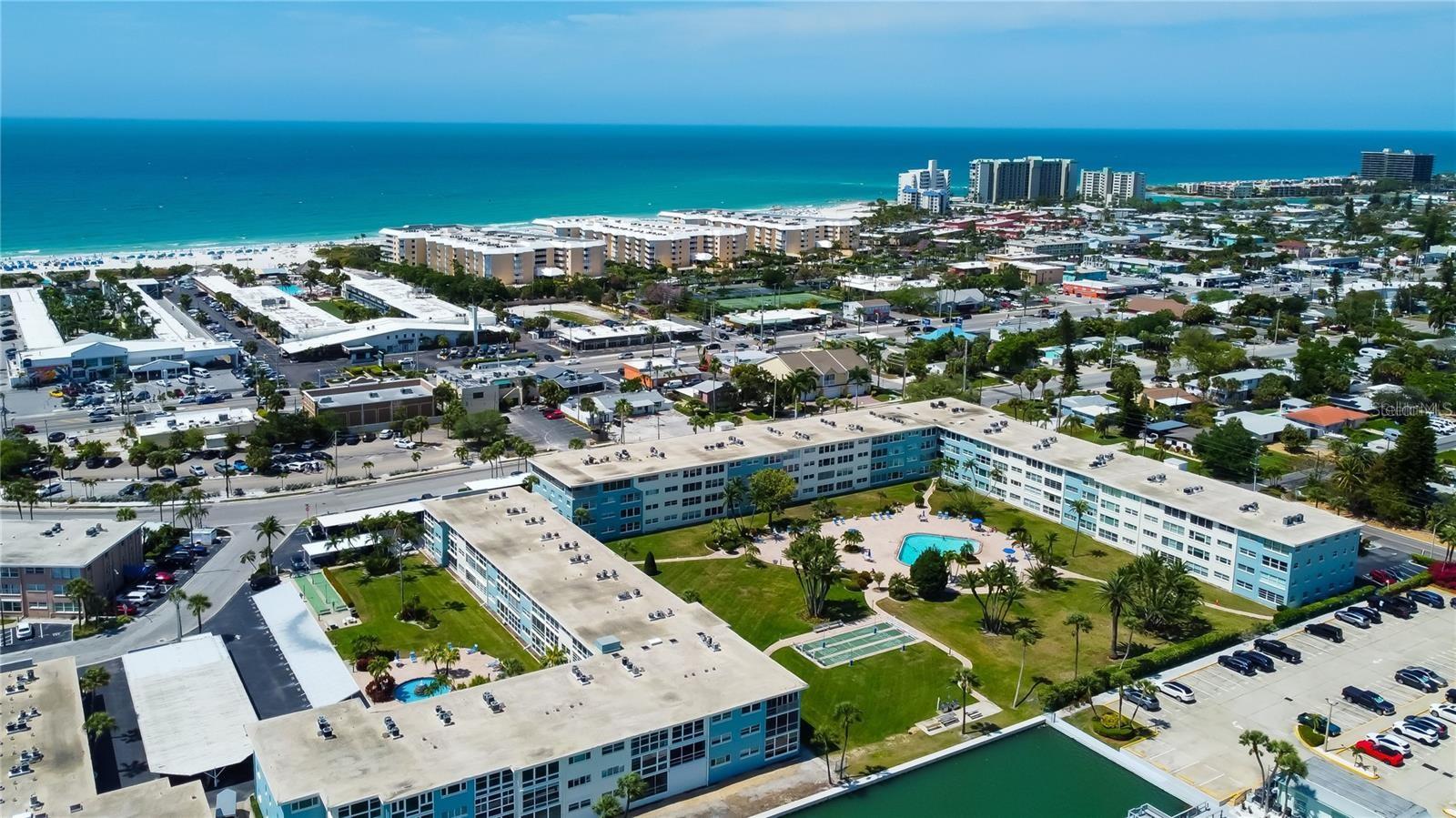 This waterfront condo community offers a 1425 sq ft corner unit with 2 bedrooms, 2 baths, fabulous water views, and is furnished and turnkey. Plus, there's a bonus room giving you the flexibility you need. Inside, you'll find beautiful hardwood floors in the living room and bedrooms, an updated kitchen, and marble floors in the baths. The open living/dining area and split bedroom plan create an inviting and functional layout. In addition to the beautiful interior, two swimming pools (one heated) shuffleboard, and laundry facilities.There is a dedicated parking space. You'll love the convenience of being a short distance to restaurants, shopping, the trolley stop, and entertainment. And beach access is directly across Gulf Blvd.