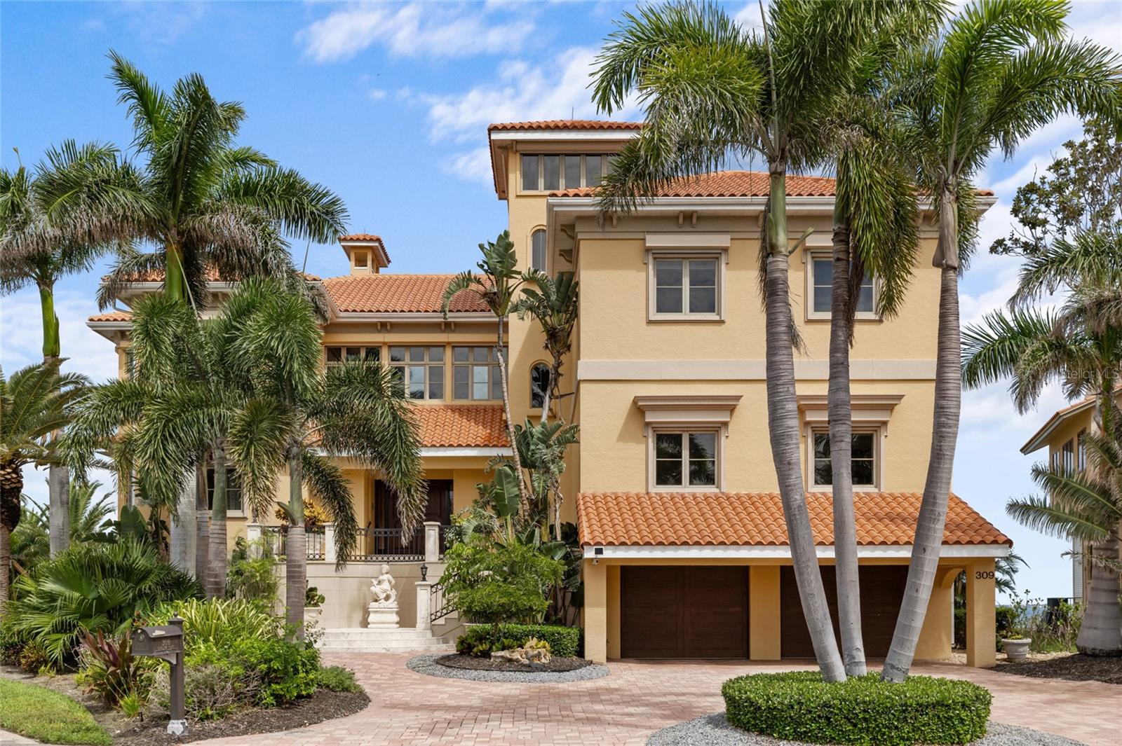 The very best value for open bayfront living near downtown Sarasota. Experience sweeping 270-degree views of Sarasota Bay from this stunning waterfront property. Perfectly positioned to capture iconic vistas of Ca’d’Zan, the former estate of John Ringling, plus the coastline of Longboat Key and spectacular sunsets. This 7,000 sq. ft. residence offers exceptional privacy and direct access to deep sailboat water. With a 17 foot elevation, this incredible home has many quality features that you must see to appreciate.
Located in Ringling Point—a private cul-de-sac of just 11 homes within the sought-after community of Sapphire Shores—this property is minutes from downtown Sarasota, yet feels worlds away. The home features 5 bedrooms, 3 full bathrooms and 2 half baths, multiple living areas, an elevator serving all floors, and a flexible layout ideal for families, entertaining, or multi-generational living.
The main living level includes a formal living room with soaring 24-foot ceilings. Walls of windows fill the space with natural light and frame breathtaking views from every angle. A gas and wood-burning fireplace adds warmth and character, while a full-service bar with a tap dispenser, beverage coolers, and custom cabinetry is perfect for entertaining. The chef’s kitchen is outfitted with custom wood cabinetry, granite countertops, dual Dacor gas ranges with stainless hoods, Sub-Zero refrigeration, double ovens, warming drawers, and two dishwashers. A spacious island with seating provides ample space for casual dining or large gatherings. An expansive terrace overlooking the bay runs the width of the main level and is accessible from the living room, bar area, family room off of the kitchen and the guest bedroom. The owner’s retreat spans the entire second-floor right wing and features a private sitting area with fireplace, a full-length terrace overlooking the bay, an oversize dressing room with double walk-through closets, and a spa-style bath with a walk-in rain shower and pedestal tub. Just outside the suite is a temperature-controlled wine room. There are two large guest bedrooms on the left wing. Additional features include a 4-car garage, recording studio, hobby and flex rooms, and abundant storage throughout. The home also includes a clay tile roof (2019) and cement block construction built on pilings.
Outdoor living is equally impressive. The newer lagoon-style pool features a grotto lounge shelf and gas-heated spa, surrounded by expansive covered terraces with tongue-and-groove ceilings and multiple seating areas to enjoy spectacular sunsets. The private dock extends into the bay, offering deep water access ideal for sailboats and larger vessels—with no fixed bridges to the Gulf.
This prime location offers convenient access to downtown Sarasota, Gulf beaches, the Ringling Museum, IMG Academy, University Town Center, and Sarasota-Bradenton International Airport. A rare opportunity to own a legacy estate with unmatched views, quality, and location in one of Sarasota’s most desirable bayfront communities.