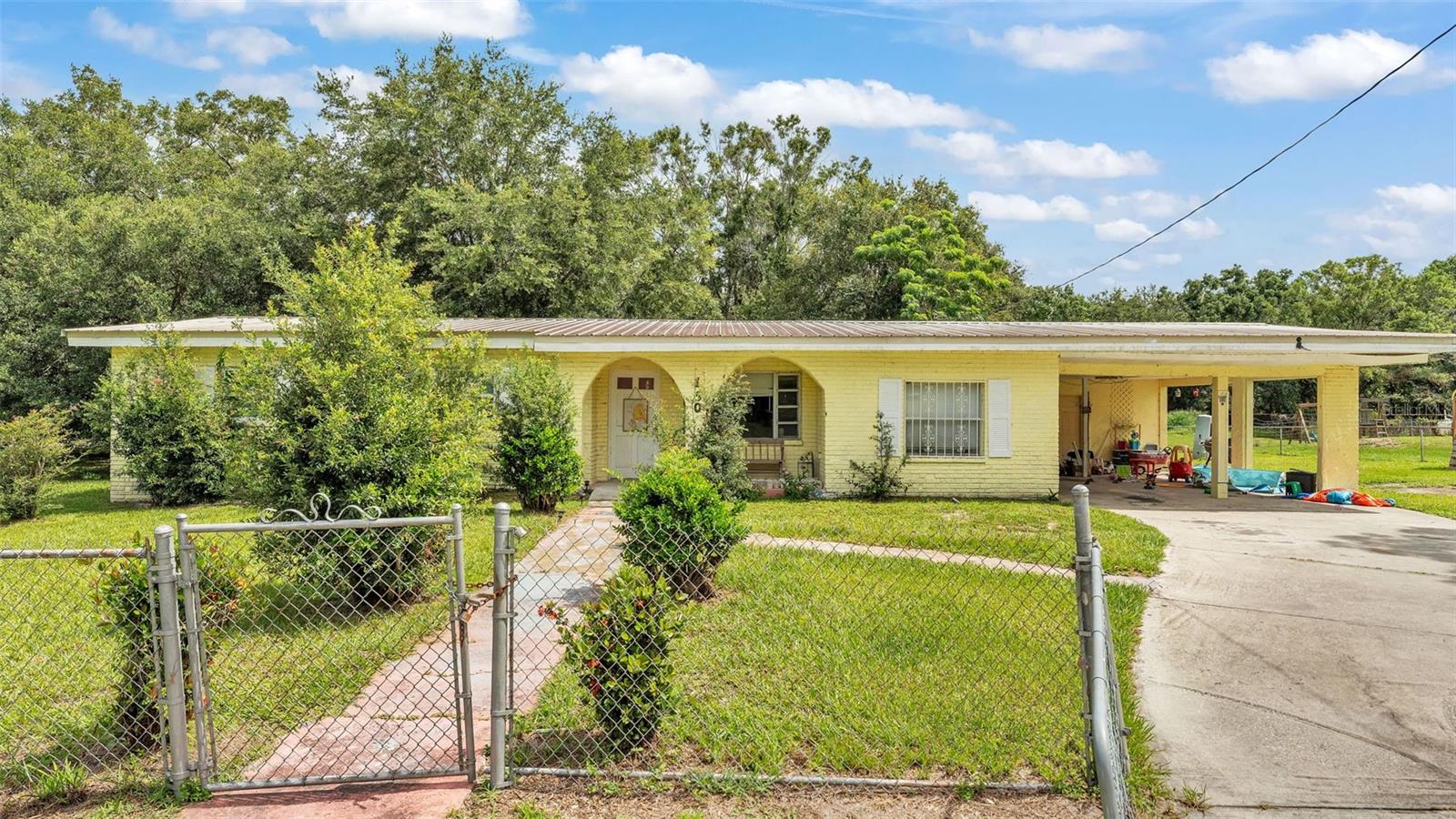 Great opportunity on a TRIPLE LOT (150 feet wide) in Mulberry/Bradley, with NO HOA... This 4 bedroom, 3 bathroom home is ready for you to make it home (or add a proven rental property to your investment portfolio)! With room to spread out on over a third of an acre, you can bring your animals, gardening tools, trucks, toys and imagination to this charming property. This home features an inviting front porch, spacious carport, tile throughout (no carpet), in-law suite with private entrance & sitting area, large bedrooms with ample closet space, ensuite bathroom in the primary bedroom, open kitchen/living/dining room concept and recent improvements like a newer HVAC and a durable metal roof. This property is a rare find at this price point... call today to set up your virtual or in person tour!