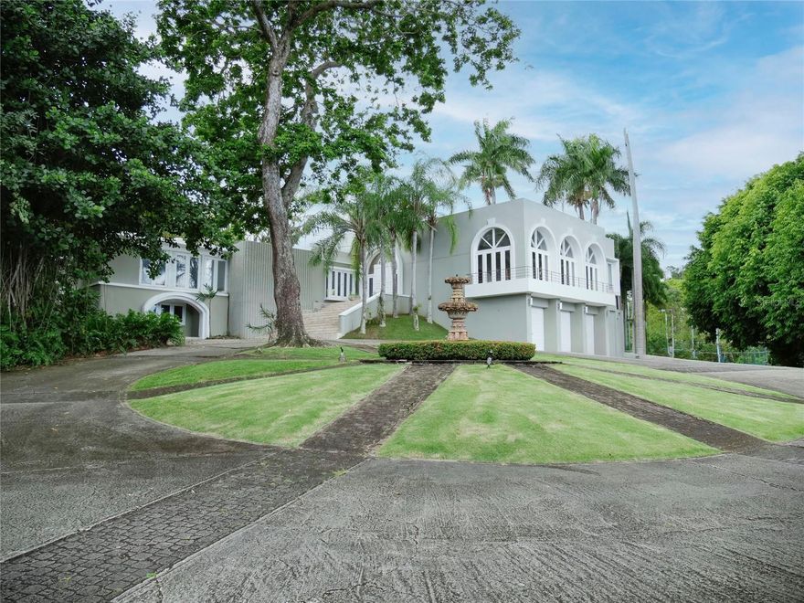Enjoy living in this tropical Paradise, in your own private resort on a hilltop overlooking San Juan and the ocean in the distance, and yet only 6 miles from San Juan. This impressive 7,538 S/M luxurious estate is a true oasis surrounded by lush gardens and century old trees. The residence boasts magnificent marble floors throughout, majestic cathedral ceilings in the commanding Great Room, a chef's kitchen with top of the line appliances opening up to a modern dining room and a huge covered terrace, great for entertaining, and all overlooking the pool, tennis court (being renovated), a fire pit, a gazebo, a bar and wine room. The home also features an office or library, a large fully equipped media family room, also all overlooking the terrace, pool and tennis court. The home boasts seven bedrooms with en-suite baths, including a complete separate apartment, or guest quarter with its own entrance. An oversized laundry room, a caretaker’s bedroom (now a gym) with en-suite bath, three separate garages, a large full generator and a cistern complete this magnificent one of a kind suburban estate. Tintillo Hills is an exclusive enclave and one of the most secure double-gated communities in Guaynabo. This unique estate benefits from close proximity to Condado and Guaynabo’s best schools, restaurants, and cosmopolitan living while you indulge living in a secluded oasis, a tropical paradise, your own private resort. For qualified buyers by appointment only.