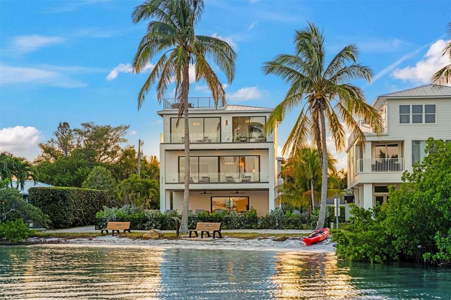This exceptional, brand new custom estate home is being offered fully furnished and reveals some of the most commanding views Longboat Key has to offer. Built by Mason Martin Builders, the level of craftsmanship and construction is as unmatched as the beauty of its location. Featuring stylish and inviting living spaces, intricate design touches, and superior construction, this home sets the highest standards for luxury living. Desirably located in historic Longbeach Village, no detail has been overlooked in creating a haven of unparalleled sophistication and comfort. Encompassing 4 bedrooms and 3 ½ bathrooms, this picturesque property offers expansive indoor-outdoor living spaces and breathtaking panoramic views. The home spans three levels, each thoughtfully designed to maximize the unobstructed water views and to bring in an abundance of natural light. Convenience is paramount with an elevator serving all three floors. Outdoor living is highlighted by a sprawling travertine patio, private saltwater pool and spa, covered areas for dining and lounging, and an indoor/outdoor Sonos system, setting the stage for year-round soirees. A custom-built spiral staircase will take you from the third level to the rooftop deck, offering endless panoramic views of Sarasota Bay. The gourmet kitchen is appointed with solid wood cabinetry and fitted with Wolf and SubZero appliances. Quartz countertops and an opulent mix of specially sourced tiling adorn the home and designer roller shades control the natural ambient lighting and offer extra privacy if desired. The epitome of luxury is found in the primary suite featuring expansive glass and boasting impressive full water views from every angle, and an ensuite bathroom showcases a floating double vanity and free-standing soaking tub. Ample storage is provided in the spacious primary walk in closet with built in custom shelving. Built with meticulous attention to design and detail this estate evokes a one of a kind coastal living experience, on the exclusive north end of Longboat Key.