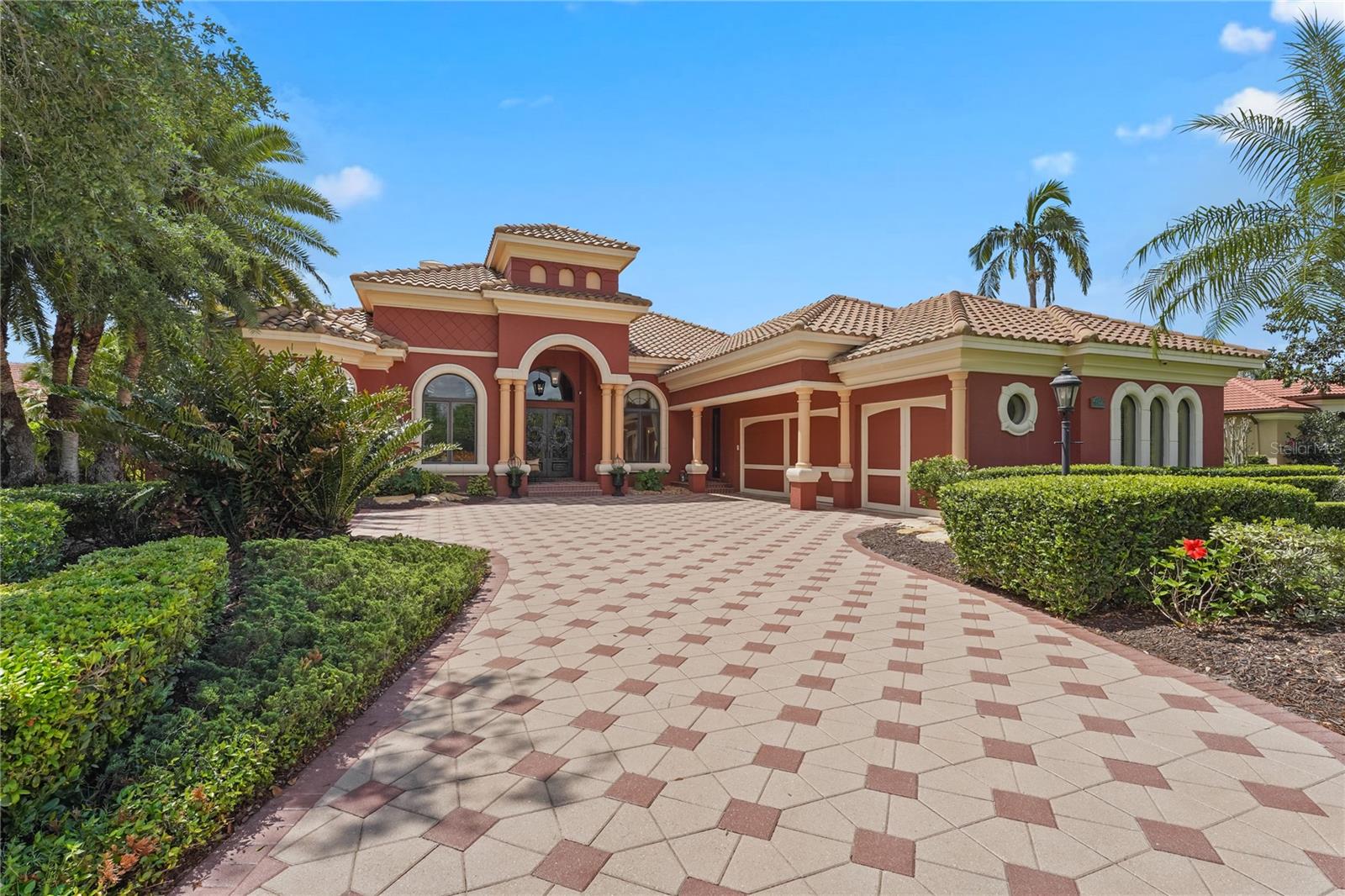 Imagine waking up every morning in the home you've always dreamed of — where elegance, comfort, and resort-style living blend together effortlessly. Welcome to 7580 Preservation Drive, a masterpiece of luxury custom design, crafted by the renowned Arthur Rutenberg, nestled behind the exclusive gates of The Preserve at Heron Lake — an intimate enclave of just 32 distinguished residences.
From the moment you arrive, you’ll feel the embrace of timeless sophistication. Step through grand, custom-designed double doors adorned with intricate glass artistry, and you'll instantly recognize you’re somewhere extraordinary.
To your left, a private office with bespoke built-ins offers the perfect retreat for work or creativity. A few steps further, indulge in a bottle from your personal, climate-controlled wine cellar, conveniently positioned next to a wet bar ideal for effortless entertaining. Beyond the wine cellar, the formal living room — currently styled as a stunning piano room — welcomes guests with soaring coffered ceilings, a cozy fireplace, and sweeping floor-to-ceiling windows that frame breathtaking views of sparkling pool fountains and serene waterfalls.
The primary suite is a sanctuary of refined luxury, featuring a double tray ceiling, a bay window that floods the room with natural light, and picturesque views of the pool. On the way to the spa-like primary bath, you’ll pass your private morning bar complete with a sink and built-in refrigerator, along with beautifully customized dual walk-in closets. The ensuite itself is a retreat, offering a rainfall walk-in shower, an elegant soaking tub, and a dedicated vanity station perfect for everyday luxury.
The heart of the home — the chef’s kitchen — is outfitted with top-of-the-line Viking appliances, rich custom cabinetry, and striking stone countertops. The adjoining family room features a dramatic double tray ceiling, a tailored entertainment center, and sweeping corner sliders that allow for a seamless transition to the breathtaking outdoor living space. Just off the family room, a bonus room awaits — ideal for a cocktail lounge or billiards room — complete with an additional wet bar, wood-beamed ceilings, and direct access to the pool deck.
Step outside and prepare to be captivated. Your private outdoor oasis rivals a five-star resort, complete with a dazzling pool with fountains, a pergola-covered spa, outdoor shower, full summer kitchen with grill and wet bar, a gas fireplace surrounded by a tranquil fountain feature, and an expansive separate seating area — all thoughtfully designed for unforgettable gatherings. Situated on nearly an acre of prime waterfront, you'll enjoy sweeping lake views and endless space to entertain or simply unwind in complete privacy.
Throughout the residence, a state-of-the-art Crestron whole-home sound system provides the perfect soundtrack to your life, whether hosting guests or enjoying a quiet evening in.
7580 Preservation Drive is more than just a home — it’s a lifestyle, an experience, and a rare opportunity to own a true work of art in one of Sarasota’s most exclusive communities.
Schedule your private tour today and discover why you won’t want to leave.