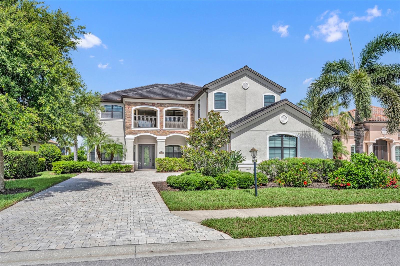 Experience the pinnacle of luxury living at 5531 Arnie Loop, an impressive and expansive residence nestled within the sought-after gated enclave of Lakewood National. Perfectly positioned to capture breathtaking views of both the lake and the championship Arnold Palmer-designed golf course, this six-bedroom, four-bathroom pool home seamlessly blends refined elegance with relaxed Florida resort living.
From the moment you enter, you’ll be struck by the grandeur of the home’s soaring ceilings, elegant architectural details, and the seamless flow of indoor-outdoor living. The gourmet kitchen is a culinary dream equipped with a gas cooktop, dual ovens, granite countertops, tile backsplash, and a charming breakfast nook designed to inspire intimate family meals or grand-scale entertaining.
The expansive family room opens to a spectacular two-story screened lanai, complete with a sparkling saltwater pool, heated spa, and a fully equipped outdoor kitchen, perfect for alfresco evenings and serene sunset views. The private guest suite on the main level is thoughtfully located with easy access to the pool bath.
Upstairs, dual staircases lead to a versatile loft, ideal for a home office, media lounge, or studio. The opulent primary suite offers a true sanctuary with its private screened balcony, panoramic water and golf course views, dual walk-in closets, and a spa-style bath featuring a soaking tub, dual vanities, and walk-in shower. A second master suite provides the perfect space for extended family or visiting guests, while additional bedrooms provide direct access to the expansive upper balcony.
Additional features include a formal living and dining room, a desirable side-load three-car garage, and an abundance of natural light throughout.
Living in Lakewood National means enjoying a maintenance-free lifestyle with world-class amenities: two 18-hole Arnold Palmer courses, an elegant clubhouse, resort-style zero-entry pool with tiki bar and café, full-service spa, fitness center with classes and certified trainers, Har-Tru tennis courts, pickleball, bocce, and much more.
Located just minutes from top-rated schools, upscale shopping, fine dining, I-75, and Sarasota’s award-winning beaches—this home presents a rare opportunity to own a move-in ready estate with every luxury imaginable.