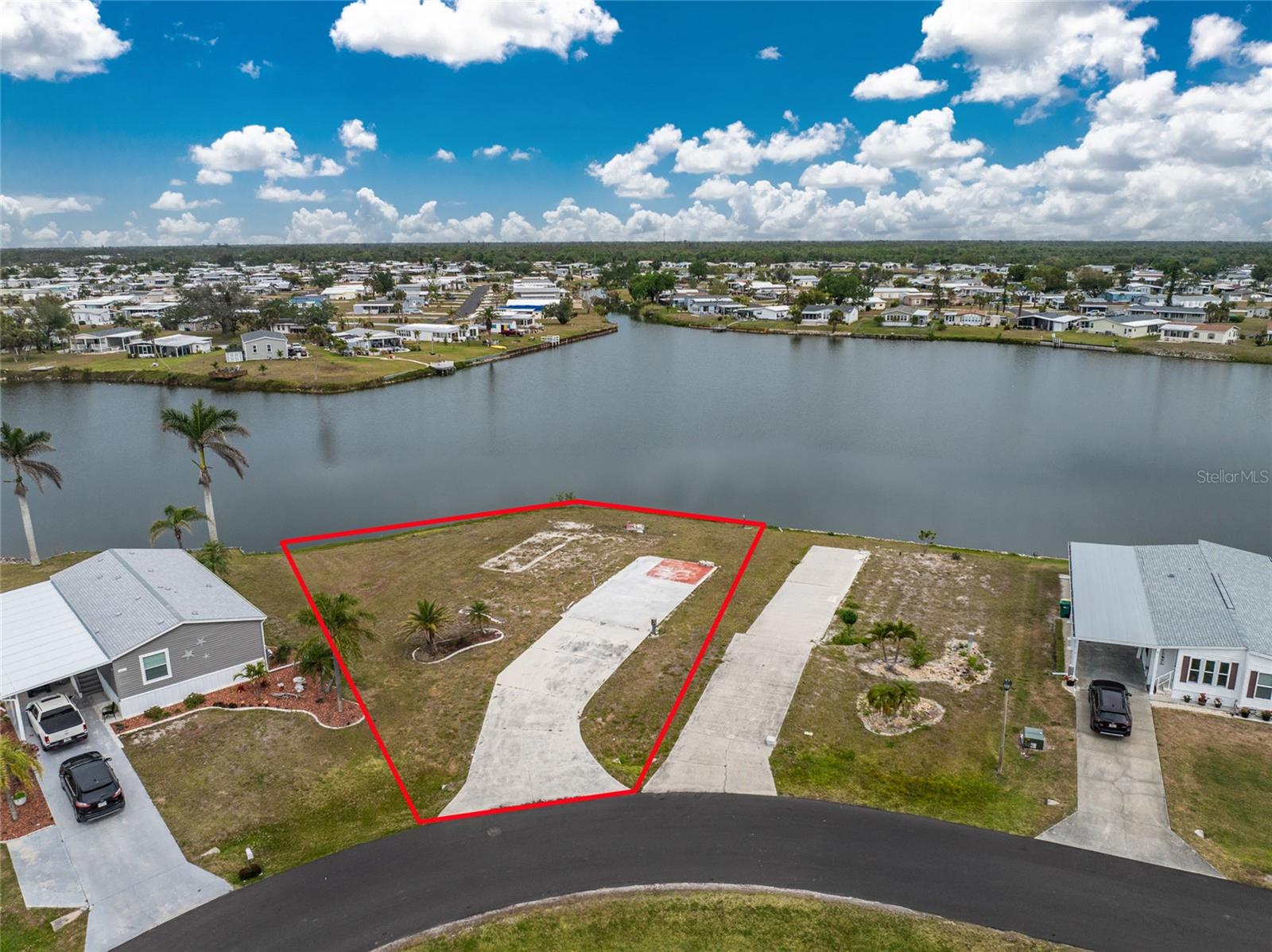 OVERSIZED PREMIER LOT WITH WATERFRONT VIEWS + SPECIAL OFFER ON NEW HOME! Welcome to this exceptional, extra-large 1/3-acre (12,946 sq ft) waterfront lot in the highly sought-after Lemon Bay Isles community. Formerly the site of the developer’s private residence, this prime lot offers 165 feet of serene water frontage with breathtaking sunset views, an abundance of local wildlife, and the peaceful charm of waterfront living. Build your dream Florida home—the lot is already cleared with water hookups in place, and the owner is continuing to pay the monthly water bill, saving you thousands in potential impact fees. A concrete pad is already situated to one side of the property, allowing plenty of room for a spacious home, detached garage, or extra privacy—all while maintaining wide-open views of the water. **** SPECIAL INCENTIVE*** Our preferred manufactured home dealer is offering a promotional discount on a brand-new mobile home placed on this lot! Ask for details about this exciting opportunity to save on your custom Florida retreat. Ideally located just a few lots from the clubhouse, residents enjoy easy access to a host of amenities including a heated pool, tennis courts, shuffleboard, horseshoes, putting green, and frequent social events, perfect for active and social 55+ living. Centrally located in Englewood, you’ll be close to everything—Walmart, Publix, pharmacies, gas stations, medical facilities, and only 4 miles to Englewood Beach. Plus, nearby parks, marinas, and dining make this the ultimate location for both relaxation and recreation. With a low annual HOA fee of just $50, this friendly 55+ community offers affordable, carefree coastal living. Don’t miss this rare chance to secure one of the largest and most desirable lots in Lemon Bay Isles—with a special limited-time offer to help you build your ideal home! Call today to schedule your tour and take the first step toward your Florida dream lifestyle!