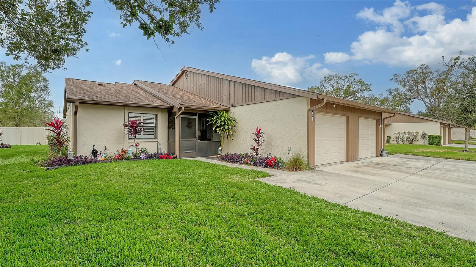 Beautifully re-modeled 3 years ago 2 BR/2BA with single garage villa/condo with two years new roof located in the wonderful community of Village Oaks. This lovely locale offers lots of mature oak trees and greenspace, a beautiful lakeside heated pool, tennis and pickleball courts. These beautiful grounds are maintained by the HOA and includes a dock on the pond by the heated community pool. This home features beautiful light gray wide plank tile flooring, crown molding throughout, plantation shutters, three fans throughout home, new garage door and lots of beautiful cabinetry. The kitchen features a granite island with the waterfall motif on each side of the island and has a stainless steel sink. All newer LG stainless steel appliances in kitchen. Bar stools can remain with home. Primary bedroom has large walk-in closet and another closet with barn door entry for more storage space. En-suite primary bedroom affords you your own private re-modeled bathroom with tiled shower walls and pebble look tile flooring. Corian solid surface bathroom counter. Second bedroom has the bathroom conveniently located by the bedroom entrance. Second bathroom features a beautifully tiled bathtub/shower with solid surface granite countertop. Laundry room features GE washer and dryer and shelving for storage. Beautiful tiled screened lanai off of great room and primary bedroom. Great room features custom built-in electric fireplace with gorgeous cabinetry for lots of storage. Kitchen opens up to great room affording you a gorgeous open floor plan. Screened-in front porch with seating area. Village Oaks is close to downtown and minutes away from UTC Mall and the world class rowing lake. It is located in the preferred “X” flood zone. Downtown Sarasota is close by and known for its unique restaurants and theaters. World class beaches are nearby along with golfing and boating. Village Oaks is pet friendly allowing one small dog or cat up to 35 lbs. Come enjoy this picturesque community.