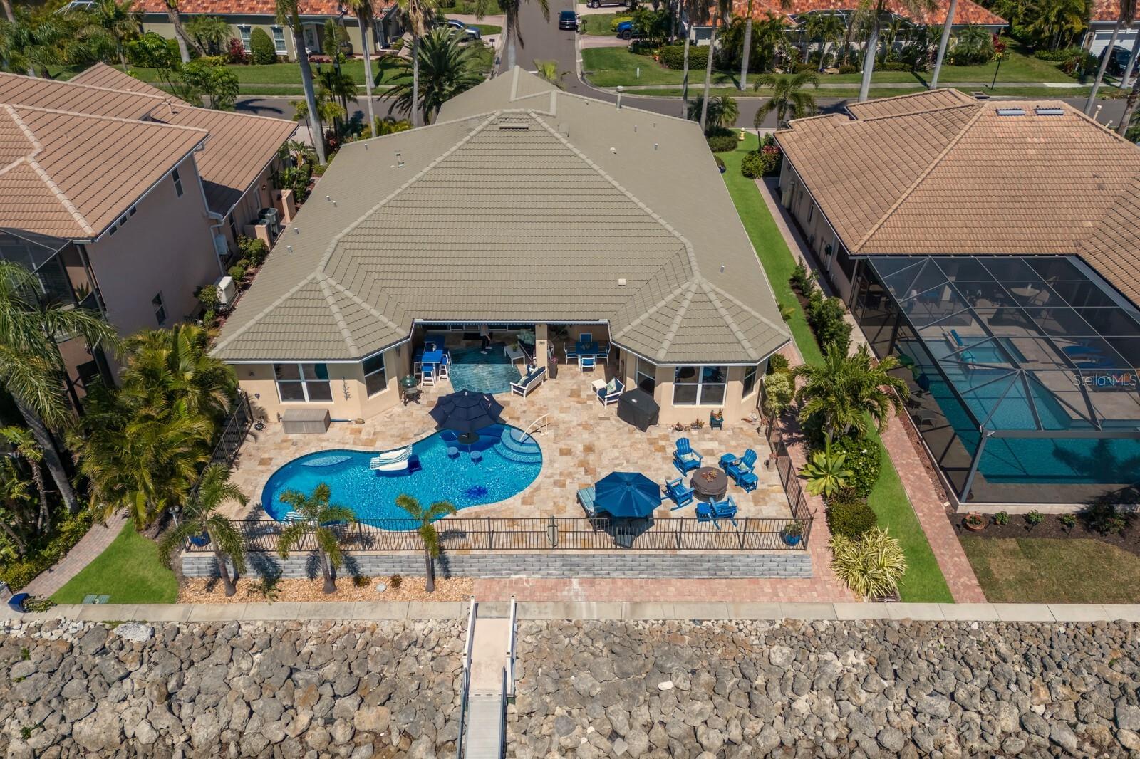PRICED TO SELL! WATERFRONT HOME WITH 60 FT. BOAT DOCK, BOAT SLIP, Deep Water and jet ski lift with direct access to the Manatee River, Gulf, ICW. PRIME LOCATION! Luxury Living in an exclusive Gated Community! Perfect as a second home or year-round residence. Discover stunning views and gorgeous landscapes in this spectacular three-bedroom+office, three-bath home with a three-car tandem garage featuring extra storage and a workbench. Enjoy an expansive veranda and covered lanai with a heated and chilled pool, all overlooking the sheltered deep-water safe harbor of Riviera Dune. No CDD’s—but with all the amenities including a clubhouse, social gatherings, fitness center, pool, tennis, and pickleball courts and the Dockside Restaurant, Tiki Bar, and marina within walking distance through a private walkway.Entertain effortlessly in the updated gourmet chef’s kitchen, thoughtfully designed with high-end finishes including a culinary island, quartz countertops, white cabinetry, and a spacious walk-in pantry. The kitchen is further enhanced by a butler’s bar with wine cooler, built-in desk area, and top-tier SubZero and Thermador appliances—featuring double ovens, gas cooktop, ice maker, trash compactor, and a reverse osmosis water system. Adjacent to the kitchen, a flexible living area adorned with a crystal chandelier and custom built-in bar buffet offers versatility as a formal dining room, game room, or lounge. The great room showcases tranquil water views through expansive sliding glass doors and is complemented by soaring ceilings, tropical ceiling fans, and a cozy gas fireplace. The spacious primary suite provides a serene retreat with wood flooring, remote-controlled Hunter Douglas window treatments, and a spa-like en-suite bath featuring dual vanities, jetted tub, bidet, frameless walk-in shower with rain head and accent tile, and an oversized walk-in closet with automatic lighting.
Additional highlights include a new Carrier A/C system, cement tile roof, plantation shutters, solid core doors, built-in surround sound, central vacuum system, Alexa-compatible lighting and fans, custom tile flooring, fiber optic internet, and a whole-home generator that also powers the dock. The fenced travertine pool deck is ideal for relaxing or entertaining under the lanai with three ceiling fans, remote sunshades, outdoor showers, TV wiring, and a gas firepit. Enjoy magnificent southwest harbor views from your private 60-ft floating dock with ramp, water and electric, 50-amp pedestal, electric JetSki lift, fish cleaning station, and included Jon boat. Boat lifts may be added. Conveniently located in the growing town of Palmetto, near major highways, Tampa, Sarasota, Lakewood Ranch, airports, hospitals, shopping, waterfront dining, and gulf coast beaches. Call for your private showing today.
