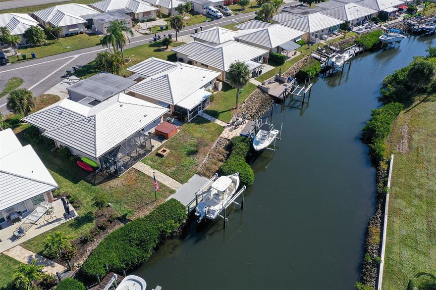 Waterfront villa offering MAINTENANCE-FREE LIVING just minutes to the ICW with no bridges! This 2BR/2BA home features a 2024 10,000 lb BOAT LIFT with water & electric, new Trex decking and epoxy concrete, HURRICANE IMPACT WINDOWS/DOORS, and a ROOF from 2019. Inside, enjoy a 2024 TOTAL KITCHEN REMODEL with quartz counters, backsplash, NEW GE appliances, and OPEN FLOOR PLAN. Additional upgrades include UV light in air ducts, re-piped plumbing, new Levelor blinds, and screened front/back lanais with custom lighting and pavers. Community amenities include pool, cabana, and boat docks. Conveniently located near beaches, Legacy Trail, golf, state park, and downtown Venice & Sarasota—this villa is all about the Florida lifestyle! FLOOD INSURANCE POLICY IS TRANSFERABLE!