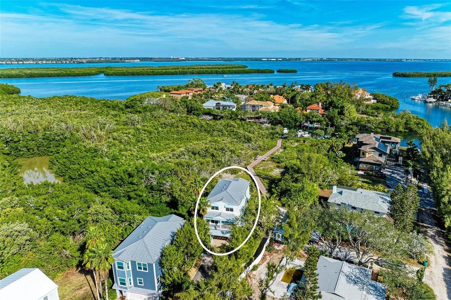 Live the Island Lifestyle in a home built exactly for just that!  6326 Laguna Drive, Longboat Key is a must see home if you have ever dreamed about living on an island, steps from world famous beaches, access to water for boating fun and a home built with nothing but efficiency and cozy living wrapped up in a luxurious setting.  This truly wonderful home is tucked in the back of a quiet gated community with only 6 other homes. This home sits on the back side with relaxing views of the canal, the mangroves, and beautiful sky's from the porch you will spend most of your days enjoying.  Fully furnished throughout including the cozy seating, gas fire fit and table for 6 on the back porch.  So much thought was put into every inch of this home.  On the main living floor, you will enjoy cooking on the large island ready for entertaining.  Induction stove and a set up built for gourmet cooks from anywhere.  Keep the wet bar fully stocked with all the fixings for a great bartender and fill up the wine fridge with the finest wines and champagnes.  You can choose to eat indoors at the round table for 6 or move out to the screened in porch as you enjoy the night sky's. This level also has a beautifully decorated half bath for easy access. All four cozy bedrooms are on the third level that you can either take the steps or ride the elevator up to.  The elevator goes to all levels.  From the garage to the top.  The primary bedroom with ensuite is nestled on the back side of the third floor so you can relax and get ready in comfort as you take in those amazing views.  The other 3 bedrooms are just down the hall and a large beautiful full bath with dual sinks and a tub shower combo is right in between.  This home is ready for you to simply make keys and get to living as it comes fully furnished, minus a few exclusions.  For the water enthusiast, there is a deed boat slip just down the walkway through the preserve or the Gulf of Mexico just across the street.  The boat slip comes with a floating dock or is ready for you to install a lift if you wish.  Not only do you have access to a water for boating, kayaking, SUP's, fishing and other activities in this community, there is also a community pool at the front of the complex.  Bask in the sun and take a dip in the pool to cool off or just relax.  After a long day in the sunshine, come home and jump into the full sized hot tub in the back of the home.  Perfect for relaxing after a long day in the sun.  Other perks you will find on the ground floor, you'll find a 2 car garage, the large indoor laundry room, a 2nd living room and more enclosed storage for all the toys and extras you may need to tuck away.  From top to bottom and from canal side to beach side, you will be hard pressed to find a better home for you to live the island life in paradise.   To get the FULL PICTURE,  you MUST SEE our FLY THROUGH virtual tour!  Let's get you over to your new home now!