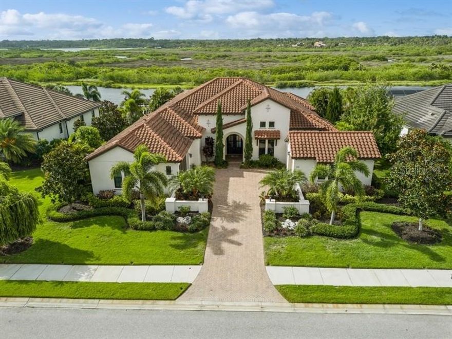 Home is a former Arthur Rutenberg furnished model with a boat dock on a canal that flows to the Manatee River ---located in The Islands on the Manatee River.  This home features 3 bedrooms each with a private bath.  The beautiful Spanish exterior welcomes you with its two garages and motor court entry. When you enter the home your eye is drawn to the beautiful pool, dock and canal.  The nature preserve behind the canal assures you that no one will ever built in your back yard.  Egrets, eagles and hawks will be your only backyard neighbors.  The view is amazing and thanks to the generouse expanse of glass in the Great Room--over 23 feet wide sliding glass doors which pocket onto the side walls--your view will always be there.  The great room and dining room open to the gourmet kitchen.  Light and bright are the words for this wonderful kitchen. A huge island with a waterfall edge is a perfect place preparing meals.  Top of the line stainless appliances and a huge pantry flanks the kitchen.  The lovely pool and spa, outdoor kitchen and clear view pool cage overlook your private dock and harbor area. The Islands has a very nice club house and athletic center for the residents of the Islands.  The Club at River Wilderness also has golf, tennis, pickelball, athletic and social memberships availbale but are not manadory.  Trucks may not be parked in the driveway overnight. HOME IS BEING SOLD FURNISHED--