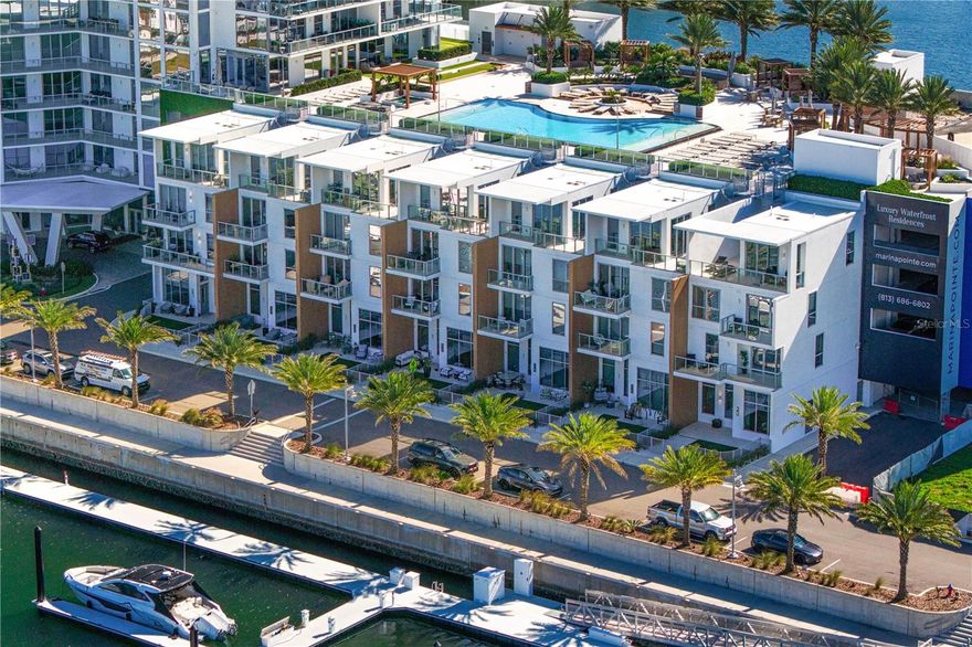 A rare offering at Marina Pointe. The only Harbour Home ever released for resale, a coveted corner and one of just seven private residences in the community. This four-level waterfront home lives like a single-family residence with the lock-and-leave ease of a condominium, featuring direct ground entry from three private parking spaces, balconies on every level, and panoramic water views. Thoughtful upgrades include new hardwood floors with sound-dampening underlay, an upgraded  2025 HVAC system, new interior doors, a custom beverage station, refreshed kitchen surfaces, whole-home and reverse-osmosis filtration, sound-absorbing wood paneling, and impact-rated windows. Level 1 living + kitchen, Level 2 full primary suite, Level 3 guest suites, Level 4 den with terrace and private spiral stair to the pool. Directly across from the residence is the deeded 40' boat slip exclusively assigned to this Harbour Home and required to be purchased with the property for an additional fee. Designed for vessels up to 45' with water and electricity, the slip delivers immediate access to open water and is one of Marina Pointe's most desirable locations. Resort amenities include the waterfront pool, spa, fitness center, clubroom, grilling areas, and marina access. Perfectly positioned between Tampa and St. Petersburg, this Harbour Home offers a lifestyle defined by privacy, convenience, and direct connection to the Bay. A rare opportunity, available for immediate occupancy.