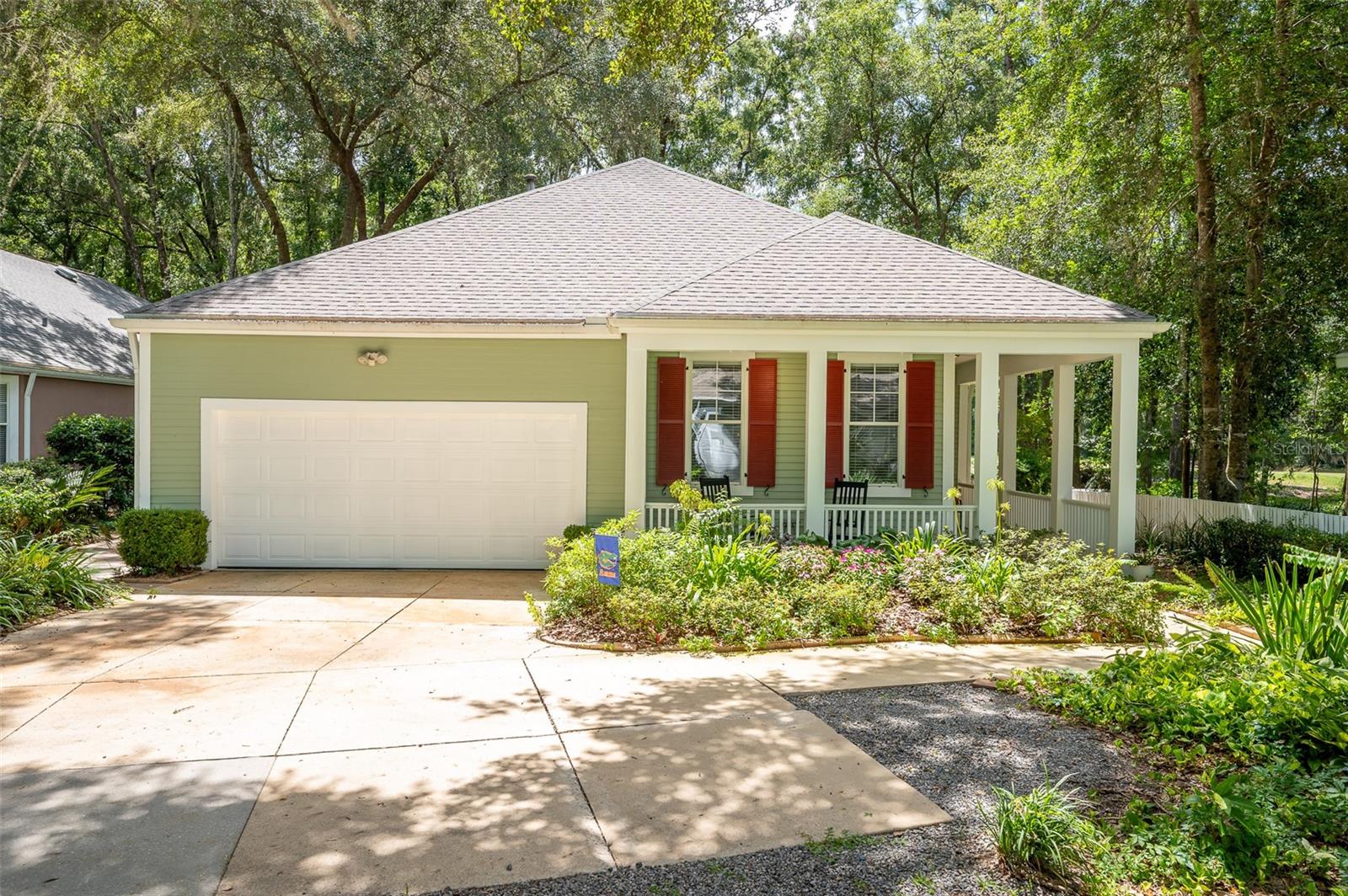 This charming 3-bedroom, 2-bathroom home in Haile Plantation's desirable Hickory Walk offers breathtaking views of the 6th fairway at Hawkstone Country Club. Lovingly maintained by its original owners, this home is all about the view! Inside, you'll find 10-foot ceilings, a formal dining room, and a spacious kitchen featuring a pantry, updated appliances, and a gas stove. The energy-efficient tankless water heater adds extra convenience. The master suite boasts sliding glass doors that lead to the screened lanai, an ideal space for entertaining. The updated master bath includes a walk-in, glass-enclosed shower. For those seeking low-maintenance living with easy access to shopping, dining, and scenic walking trails, this home is the perfect fit. Yard maintenance is included in the HOA, making life even easier. Also included 220 EV charging system in garage. Fresh market every Saturday morning in the Village is just a short walk.