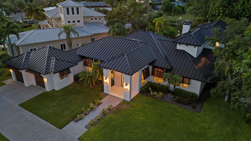 Welcome to one of Sarasota’s most coveted waterfront communities—Coral Cove, where homes rarely become available and even fewer offer the exceptional combination of elevation, design, and location that this one does. Perfectly situated on a spacious 0.59-acre corner lot directly across from the private neighborhood park and boat ramp, this British West Indies-style home has been reimagined through extensive renovations from 1999–2004 and again in 2023–2024, giving it an effective year built of 2009. This fully remodeled 4-bedroom, 3.5-bathroom residence spans over 5,000 square feet and sits high and dry above sea level, with no flood damage during recent hurricanes. With a new metal roof, brand-new impact-rated windows and doors, and solid core shaker-style interior doors, no detail was overlooked. Step inside to the tall 10-12 foot ceilings, engineered hardwood floors, and tons of natural light coming through the French doors and large sliders that lead to your private outdoor oasis. The centerpiece of the home is the chef’s kitchen featuring Café Series appliances, a fluted range hood, Dolomite countertops, waterfall-edge peninsula seating, walk-in pantry, and soft-close white cabinetry, all opening seamlessly to the living and dining areas. This home offers two true primary suites, choose between a luxurious ground-floor retreat or a private upstairs sanctuary. The upper-level suite boasts a spa-like bathroom with a freestanding tub, dual vanities, walk-in shower, and a massive walk-in closet. An additional ensuite bedroom and fourth bedroom/office are thoughtfully positioned on the main level. Outside, enjoy a large pool, limestone decking, lush landscaping, and a brand-new dock with a floating jet ski pad, great for waterfront entertaining. With no HOA and your own private boat launch just across the street, this home is tailor-made for the Florida coastal lifestyle. All this is just minutes from world-renowned Siesta Key Beach, as well as Sarasota’s vibrant shopping, dining, and cultural scene. If you’ve been searching for a luxury waterfront rental West of the Trail that checks every box—style, safety, size, and serenity—this is it.