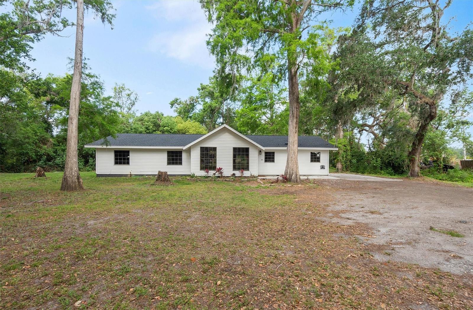Welcome to 6005 Ike Smith Rd, a fully renovated farmhouse-style retreat set on 1.56 acres in beautiful Plant City. This single-family rental offers the perfect blend of high-end design and peaceful living with the added freedom of A-1 agricultural zoning, making it an ideal property if you want room for animals, space to garden, or simply a place to breathe. Inside, you’ll find an open-concept layout with brand new kitchen cabinets and modern fixtures, fully updated bathrooms with spa-style tile showers, and new doors throughout, including a sliding glass door that opens onto the back patio. The home has been upgraded with a new water heater, updated plumbing system, and framed windows that add both charm and efficiency.
Outside, you can relax on the newly poured front and back concrete porches, spend evenings in the screened-in back lanai, or take in the quiet scenery of the river that runs through the rear of the property. With no HOA restrictions, you’ll enjoy both privacy and flexibility to make the space your own. The home offers 1,695 square feet of updated living space with three spacious bedrooms and two bathrooms, giving you a turnkey rental that is ready to move into right away. Conveniently located just ten minutes from I-4, this home provides easy access to Tampa, Lakeland, and Orlando while allowing you to return to the peace and quiet of your private retreat at the end of the day.