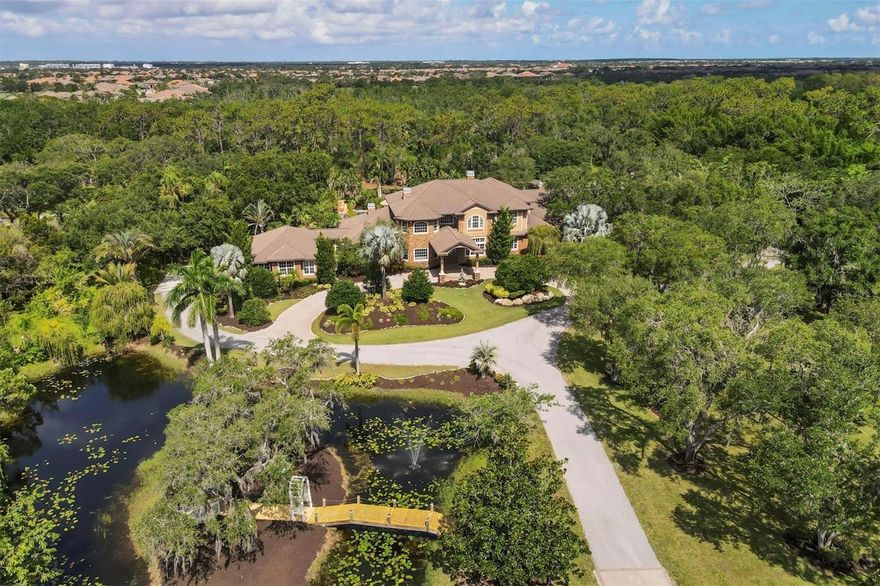 Under contract-accepting backup offers. Gated, private and luxurious estate is now available in Lakewood Ranch! Combining privacy and security across 13 acres of pristine Florida surroundings, with the convenience of being located near the heart of Lakewood Ranch, this estate is a rare opportunity that cannot be missed. This impressive residence was custom built by Jonas Yoder Custom Homes and then updated in 2021-2022 to the best of modern upgrades including luxury vinyl wood-look plank flooring throughout, renovated kitchen, 3 Trane AC units, tankless water heaters, renovated master bathroom, remote control Hunter Douglas blinds, and more. Follow the winding drive through charming oak trees from the front gate, alongside pastures and the horse stable, pass private ponds, and you arrive at the welcoming front entry with circular drive and covered parking for guests. The impressive foyer opens to immediate views of the resort-style pool and lanai. The raised formal living room showcases two-story ceilings, and convenient access to the elevator or renovated stairs to the second level. The formal dining room contains custom luxury upgrades including a temperature-controlled wine room and a renovated wet bar with icemaker. At the heart of the home is the renovated kitchen with new island, quartz counters, a hidden walk-in pantry with shelving, hidden countertop appliance storage, subway tile backsplash, and freshly painted cabinetry. Chef’s will appreciate the luxury level appliances including 36” Sub-Zero refrigerator, 36” Sub-Zero freezer, 2 new Fisher & Paykel hidden dishwasher drawers, new Franke and Kohler sinks, Viking gas cooktop, and GE Monogram double wall ovens. The adjacent dinette with corner window offers the perfect place for causal meals. The family room showcases a stacked stone fireplace, custom display bookcases, and sliders to the lanai. The oversized master suite offers the pinnacle in tranquility with a double tray ceiling, French doors to the lanai, and a raised seating area with fireplace for cozy evenings. The master bathroom features elegant upgrades with a textured freestanding tub, new Brizo fixtures, make-up vanity, and a spacious walk-in shower with rainhead, plus dual walk-in closets with custom shelving. Guests will feel right at home in the two first floor bedrooms, or the two upper-level bedrooms, plus two spacious guest bathrooms. Built for both work and play, this residence features a space for everyone and every lifestyle. The downstairs fitness room has two walls of mirrors and extra ceiling fans. The upstairs study has ample room for desks, plus built-in closets for convenience as a sixth bedroom. The oversized bonus room has a balcony with firepit, wet bar with ice maker, and a “homework bar” for studies. Enjoy movie nights in the large theatre with projector and tiered seating. Take in the best of Florida weather on the massive stone paver lanai with resort-style heated pool featuring spa, rock waterfalls, swim-up tiki bar, stepping-stone, sun shelf, and river water feature weaving across the lanai. Complementing the pool are palm trees and landscaping, two covered areas, firepit and fireplace, plus outdoor kitchen. This estate has plentiful room for all kinds of activities with split 8-car garages including storage rooms, bathroom, laundry, golf cart garage, and full RV garage. Further room for RVs, boats, and more can be found in the pole barn with vehicle lift. This estate offers the best of everything with the location you desire.