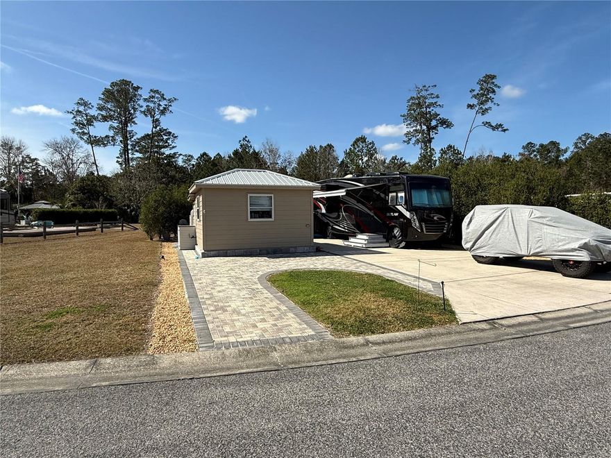 Discover the perfect getaway at this unique reverse pie-shaped deeded RV lot in the highly sought-after Wilderness RV Resort! This exceptional lot is wider at the road and features an easement buffer on the left for added privacy. Mature bottlebrush hedges on both sides enhance the seclusion, creating an intimate oasis for relaxing nights around the huge paver fire pit. Additional paver parking ensures convenience for you and your guests.
Outdoor living is taken to the next level with double screened gazebos with power, offering the perfect space for entertaining. The outdoor kitchen, complete with a TV, refrigerator, and ample counter space, makes meal prep a breeze—plus, you'll love cooking on the gas stove under the stars. With all these amenities, your RV will be just for sleeping!
Wilderness RV Resort offers a premium lifestyle with clubhouse amenities, a heated pool, nature trails, and direct access to the Ocklawaha River, perfect for kayaking and fishing. Located just minutes from historic downtown Ocala, you'll enjoy world-class dining, shopping, and entertainment at The Square. Plus, adventure awaits at the nearby Silver Springs State Park, famous for its crystal-clear spring waters, glass-bottom boat tours, and abundant wildlife.
Don't miss this rare opportunity to own a one-of-a-kind RV lot in an unbeatable location!