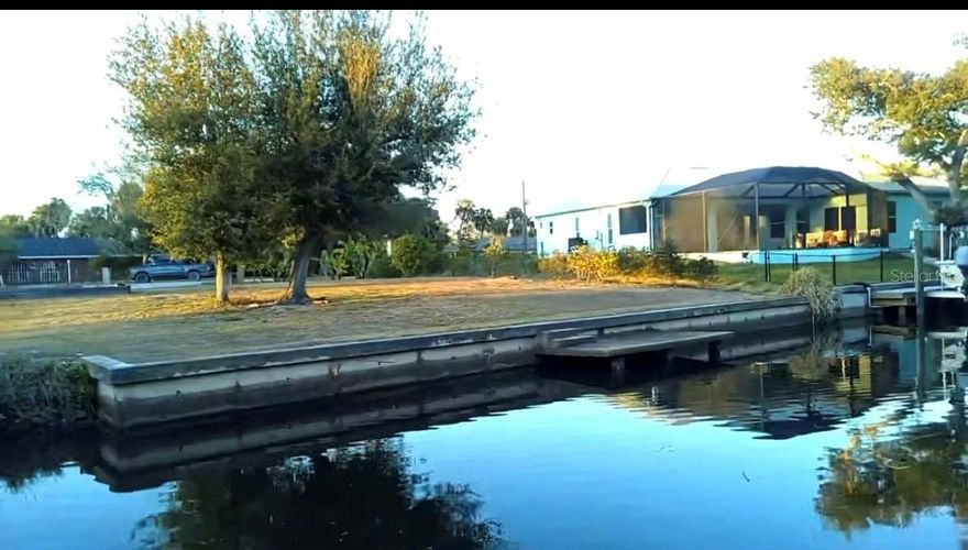 Discover an incredible opportunity to own an oversized, 0.55-acre waterfront lot on Alligator Creek, originally two lots. This beautiful parcel already features a concrete seawall and small dock, making it easy to launch a small boat (no tower) and enjoy peaceful days of fishing or breathtaking sunset cruises. With just a short boat ride, you’ll find yourself out on Charlotte Harbor, ready to explore open waters and soak in Southwest Florida’s natural beauty. Mature oak trees grace the property, and multiple types of fruit trees including avocados, mangoes, banana, creating a serene, shaded setting that enhances the privacy and charm of this special homesite. Conveniently located just off US-41, you’re only minutes from vibrant downtown Punta Gorda and have quick access to I-75 for easy travel north or south along the coast of beautiful SW Florida. 
Enjoy the close proximity to popular restaurants, beautiful parks and outdoor recreation, numerous golf courses within a 30-minute drive
World-renowned beaches like Siesta Key and Boca Grande. It's the perfect place to bring your Florida dream home to life! Whether you’re planning to build now or invest for the future, this is a rare waterfront opportunity you won’t want to miss. Secure your slice of paradise on Alligator Creek today