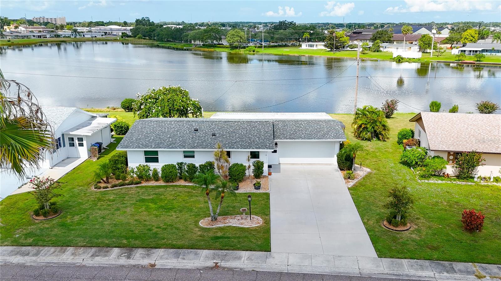Presenting this custom-built residence overlooking the tranquil Swan Lake in Sun City Center. This property offers a rare opportunity to enjoy picturesque views, whether relaxing on the rear patio observing local wildlife or hosting gatherings with friends and family in Florida’s premier 55-plus community. The home is situated on an expansive .30-acre lot with 90 feet of frontage and includes a versatile 16’ x 18’ bonus room suitable for use as a third bedroom, office, or den. Notable improvements include a new roof installed in 2021, which withstood the recent hurricane with no major damage. The layout features two full bathrooms, a kitchen-adjacent laundry closet, luxury vinyl flooring throughout the main living areas, and ceramic tile in the bathrooms and kitchen. An open floor plan enhances the spaciousness, while the two-car garage provides secure parking for vehicles and/or a golf cart. The main Sun City Center campus is conveniently accessible by cart. Sun City Center stands out for its active resident involvement, offering over 150 clubs and organizations, making it one of Florida’s most affordable and vibrant senior communities. The central location provides convenient access to Gulf beaches, medical facilities, educational resources, veterans’ support services, professional sports, museums, shopping, transportation, and major airports. Contact us to schedule a private showing of this exceptional home.