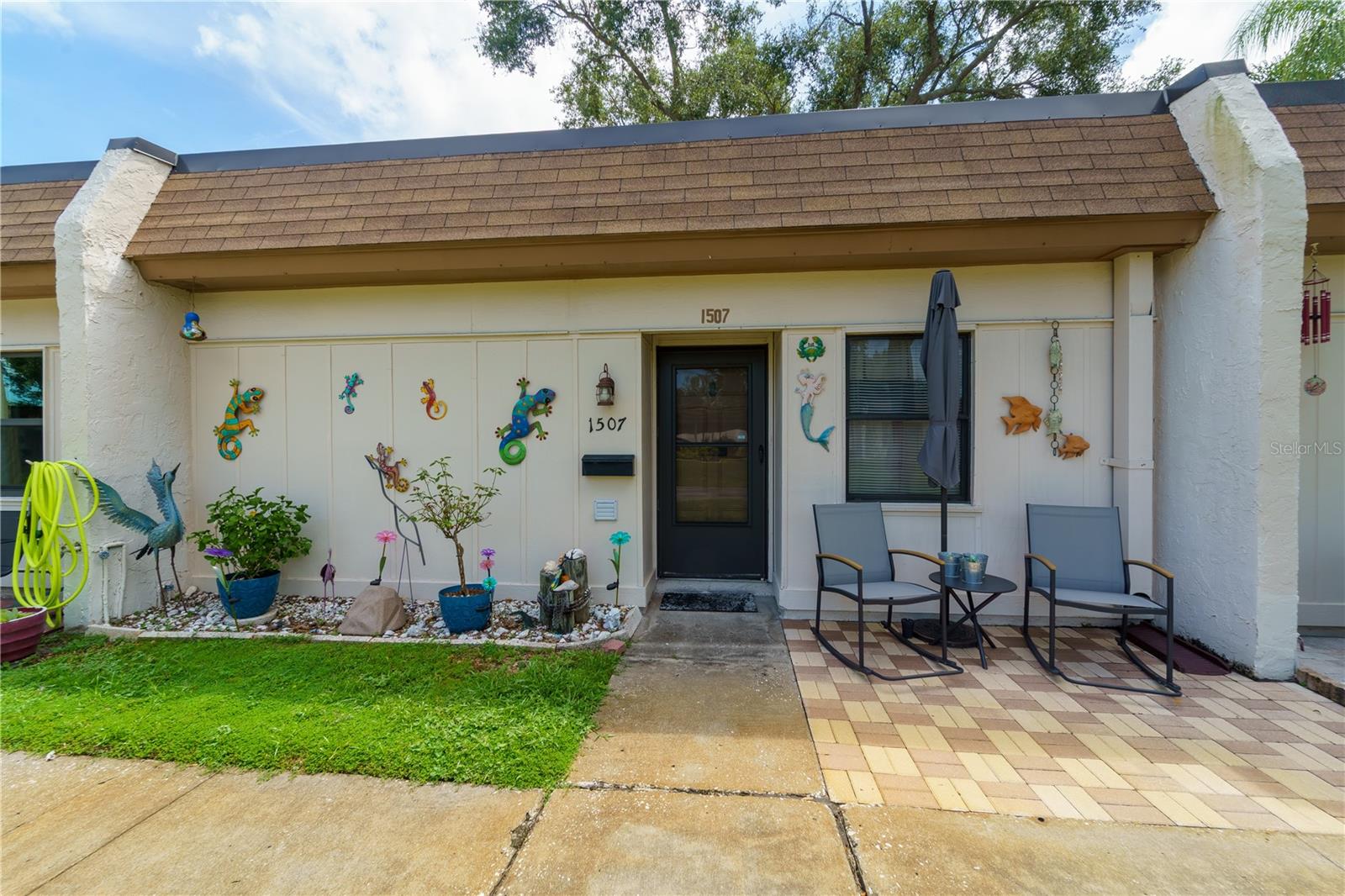 Welcome to carefree living at Mission Hills, a sought-after 55+ community where neighbors feel like family! This charming one-level villa offers privacy, comfort, and convenience in a peaceful, park-like setting. Step inside to discover an updated kitchen with modern cabinetry, durable Formica countertops, and a built-in coffee bar—perfect for starting your morning. The bathroom features an easy-access updated shower and a stackable washer and dryer tucked neatly in a closet for added convenience. The flexible porch area is ideal for hosting guests, complete with a Murphy bed that conveys with the home. Enjoy your morning coffee on the peaceful front or back patio while soaking in Florida’s famous sunshine. The rear patio overlooks mature oak trees and lush green space—ideal for growing herbs or displaying potted flowers. No upstairs neighbors here—this villa is all on one floor for ease and quiet living. It’s one of the few communities offering gas for your range, gas heat, & gas water heater—all included in your monthly condo fee! Your assigned covered parking is just steps away and includes a private storage closet. This home is sold fully furnished and stocked, ready for you to move right in. Enjoy an active social life at the community clubhouse just a short walk or drive away. Events include monthly potlucks, ice cream socials, bingo nights, and crafting clubs. Stay active with scheduled pool exercises or relax at one of the popular pool parties. The clubhouse also features a large event hall with full kitchen, game room, library, and cozy lounge area. Prime location: Walk to a local Italian restaurant, or take a quick drive—less than 9 miles—to the sugary sands of world-renowned Clearwater Beach. You're also just 2 miles from the charming town of Safety Harbor and 4 miles to Countryside Mall. This villa offers not just a home, but a lifestyle. The previous owner lovingly described the residents of Mission Hills as her “second family.” Come experience it for yourself!