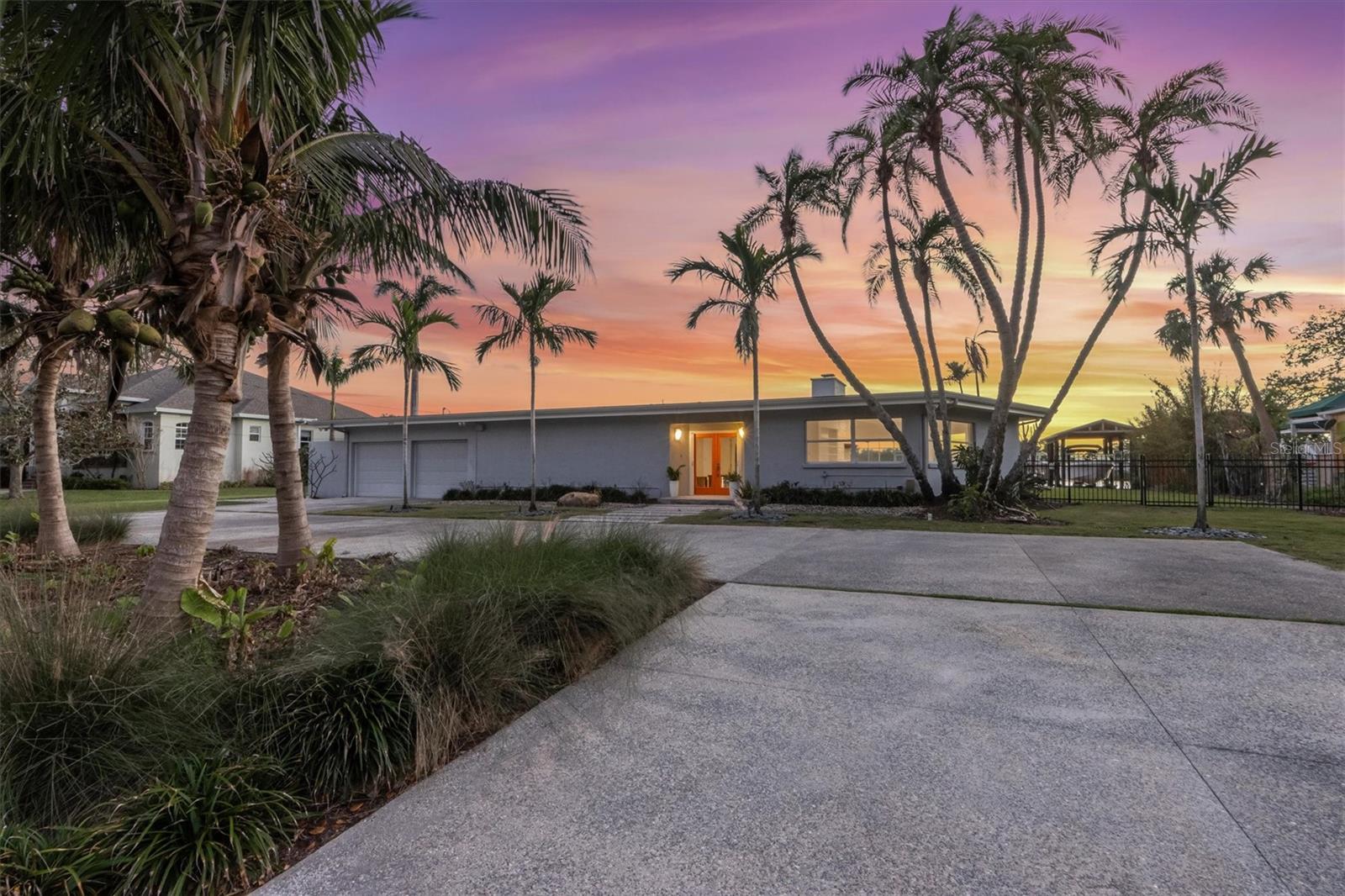 Step into this stunning midcentury modern residence, ideally positioned along the sought-after Riverview Boulevard. Offering 125 feet of waterfront views on Warner’s Bayou West, this unique property blends timeless design with serene natural beauty. Inside, the spacious 4-bedroom, 4-bathroom home showcases classic midcentury architecture in a striking courtyard-style layout. Clean lines, an airy open-concept interior, and a seamless integration of indoor and outdoor spaces create an inviting atmosphere. Perfect for entertaining, the home features 75 feet of sliding glass doors that flood the interior with natural light and frame uninterrupted bayou views. Step out onto the expansive covered lanai, where you’ll find a large saltwater pool, outdoor shower, outdoor grill, and multiple seating areas, ideal for gatherings large or small, all set against a backdrop of sunsets. Outdoor living continues with a boathouse and boat lift on the north side of the property, as well as a private dock with two jet ski lifts, perfect for boating enthusiasts or anyone who loves waterfront living. Impacted by Hurricane Helene in 2024, the home was promptly and professionally remediated and is ready for its next chapter. Whether you’re restoring its midcentury charm or envisioning a fresh start, this property presents a rare opportunity to create your dream home. Don’t miss your chance to own a piece of Riverview Boulevard, where location, land, and lifestyle come together in one exceptional offering.
