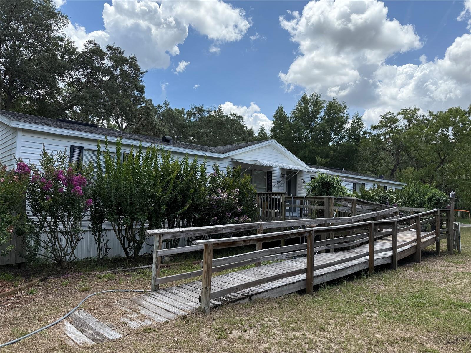 4 Bedroom, 3 Bath doublewide mobile on over one acre. Handicap ramp to front door. Beautiful, treed lot with 2 sheds, utility building. Featuring living room, family room with fireplace, eat in kitchen laundry, pantry and decks in front and back