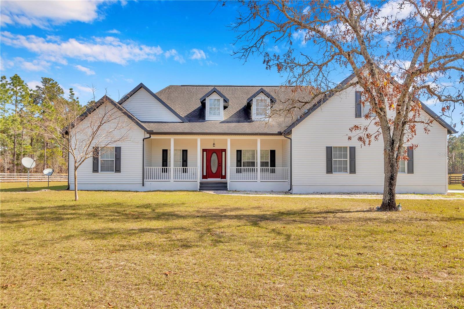 Welcome to your dream ranch home on 10 acres! This meticulously maintained property boasts an open floor plan with knotty-pine vaulted ceilings. revealing a spacious living area upon entry. The kitchen features solid wood cabinets, granite countertops and a large pantry. Enjoy the warmth of the wood-burning fireplace in the living room, complemented by hardwood floors. With three bedrooms, three baths, an office and a bonus room upstairs, this home offers versatility and comfort. Want cheap electrical bills?? This home is equipped with solar panels(2023) which will be paid off at closing. The entire 10 acre estate is securely fenced with 4 board fencing and also features three paddocks on 7 acres, each with water access. The remaining 3 acres at the rear offer a wooded retreat, ensuring privacy. For equestrian enthusiasts, a center aisle 4 stall barn(36X36) awaits. Complete with a tack room, feed room and bathroom. The barn also included hot water, electricity and a wash rack. RV hook up on the left hand side of the barn with septic clean out. This ranch home harmoniously combines modern amenities, natural beauty and equestrian facilities for a truly exceptional lifestyle. The garage has been converted BUT it is able to be converted back! You are able to horseback ride directly to the Goethe Forest or Black Prong is just down the road! Within 25 minutes of the World Equestrian Center and Ocala where you will find epic horse competitions, restaurants, medical offices, grocery stores and more. A short 20 minute drive to Dunnellon where there are dining options, grocery stores and the beautiful Rainbow River.