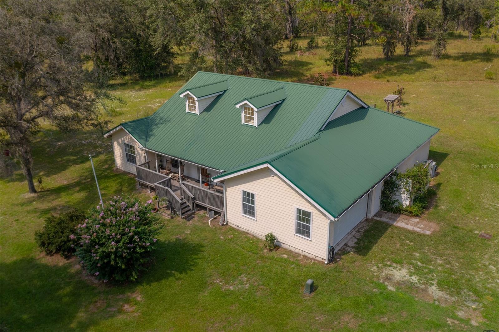 Back on Market.......BUYERS FINANCING FELL THROUGH......Don't delay......discover the perfect blend of comfort and country living with this stunning 4-bedroom, 3-bathroom home situated on over 13 acres in the heart of Gilchrist County, Florida. This spacious residence offers an inviting layout with wood floors, high ceilings, and thoughtful design elements throughout. Step inside to find a bright and open living area leading to a large kitchen featuring a huge breakfast bar, eat-in dining space, and plenty of room for entertaining. The primary suite is a true retreat with trey ceilings, a tub to soak in or a step-in shower, and ample space to relax. Enjoy your morning coffee on the charming front porch or unwind on the screened back porch while taking in serene views of the expansive property. A detached workshop or garage provides additional storage or workspace for all your projects. Whether you're seeking privacy, room to roam, or a place to enjoy the beauty of nature, this property has it all. Don’t miss the opportunity to own your slice of paradise in Gilchrist County—schedule your private showing today!