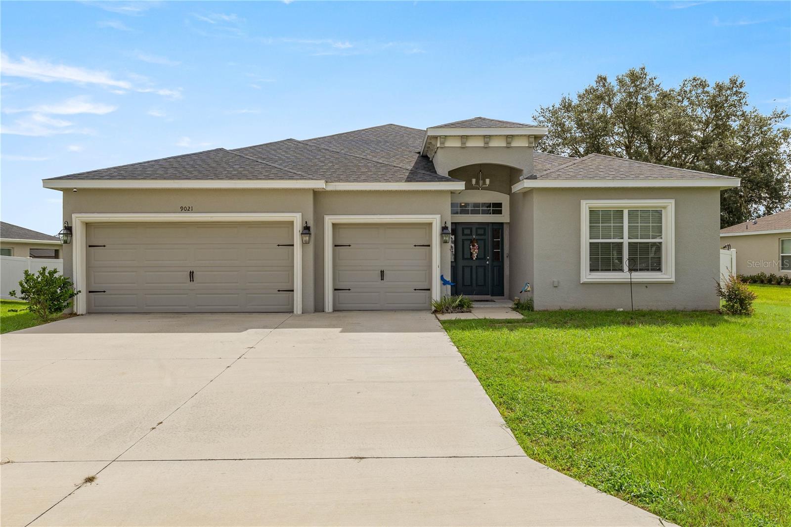 Welcome to this stunning 2022 Williamson II model home, move-in ready and nestled in the sought-after all-age community of Summercrest. Just three years young, this residence offers a thoughtfully designed triple-split floor plan with 4 bedrooms plus an office/den, 3 bathrooms, multiple living spaces—including both a living room and great room—as well as a spacious 3-car garage. Three mounted TVs convey with the home, and a security system with monitor provides peace of mind. Step inside to soaring ceilings with tray accents in the primary suite, creating an open and elegant feel throughout. The expansive primary suite provides ample room for your bedroom furnishings, a private sliding glass door to the lanai, and a luxurious en-suite bath featuring dual sinks, abundant counter space, a soaking tub, separate shower, and a large walk-in closet. The gourmet kitchen is beautifully appointed with white shaker staggered cabinets topped with crown molding, gleaming granite counters, a full stainless steel appliance package, a closet pantry, and a generous breakfast bar perfect for casual dining. A new all-in-one washer/dryer combo maximizes efficiency while also freeing up extra space in the laundry room. Relax on the covered lanai and enjoy the fully fenced backyard—ideal for entertaining, gardening, or giving your furry friends room to roam. Summercrest is a gated, highly desirable community conveniently located near shopping, medical facilities, fitness centers, and more. This exceptional home truly combines comfort, style, and convenience in one perfect package.