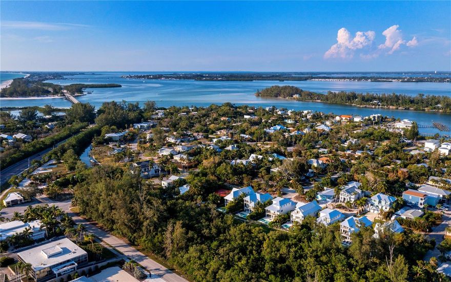 Enjoy village lifestyle in this beautifully updated home.  The canopied street is a favorite on the key and the property provides a quiet and tranquil setting.  Just a short distance to multiple beach and bay access points and a community boat ramp and fishing pier.  An unusually large fenced lot (100x150 feet) provides numerous options: expansion of house, addition of a pool and boat storage.  The home has two bedrooms, two baths, family room or den, attached laundry room and two car garage, plus a separate large storage shed on the property.