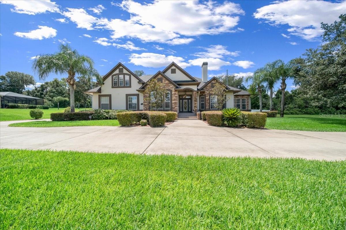 Welcome to your private oasis in The Arbors—a beautifully maintained, gated community offering peace, privacy, and unbeatable location just minutes from town. Tucked at the end of a quiet cul-de-sac on over an acre, this former Parade of Homes model is a showstopper from start to finish. Thoughtfully designed with a triple-split floor plan, this 4-bedroom, 4-bath pool home is filled with upscale finishes and timeless character. From the lush landscaping and circular driveway to the fully fenced backyard with its own irrigation well, every detail speaks to quality and care. Inside, you'll find architectural ceilings, classic crown molding, antique-inspired lighting, the office/bonus room features a stunning, custom wood double-sided gas fireplace with detailed millwork and stone surround that also warms the living room. A formal dining room with hand-crafted wood ceiling adds elegance to every gathering. The heart of the home is a chef’s kitchen—complete with granite countertops, gas cooktop, double ovens and abundant cabinetry—seamlessly opening to a welcoming family room. Bar seating and a sunny breakfast nook make casual dining a breeze. The primary suite is its own retreat, featuring dual walk-in closets, granite vanities, a jetted tub, and a spacious walk-in shower. Zoned A/C keeps every corner comfortable year-round, and the chlorine-free pool—secured with a custom child safety fence—makes outdoor living both safe and stylish. This home is the perfect blend of luxury, comfort, and convenience. Come experience it for yourself—your next chapter starts here. Electric Vehicle? No Problem, there is a certified charging station hook up in the garage for easy use! New Roof 9/2024 with Titan Hurricane-rated up to 150 mph architectural shingles with cooling technology and top tier durability. Many more updates for added value on attachments.