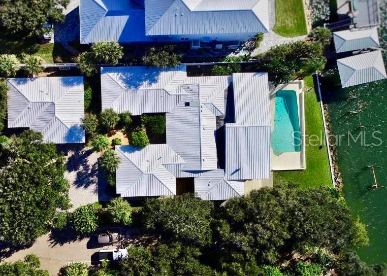 Mesmerizing river views & sunsets from this tastefully remodeled 1962 ranch style river home. Numerous upgrades maintaining the home’s character & charm will be seen throughout the sprawling Florida single story. 5 beds & 6 baths with newly polished terrazzo floors in kitchen & main living areas. Amazing views of the river throughout, although the views from the 56’x23’ climate controlled Florida Room with floor to ceiling windows are breathtaking. Formal dining room overlooks the river with oak flooring and a large picture window. All kitchen appliances have been upgraded, including the 5 burner natural gas cooktop, and complement the mid century cabinetry. An enormous master suite faces the river and features a 7’x12’ closet custom designed by Top Drawer. Bath features large bubble tub, dual vanity, granite tops & huge shower with dedicated high flow gas water heater. Guest wing of main house includes 3 large bedrooms set up as suites each with their own. bathroom(one handicap accessible). Theater room; engineered for perfect picture and sound via the Marantz Home Theater System, 110” JVC
projector and Klipsch speakers(over $30k in upgrades). What a great place to unwind after a tough day at the beach, on the river or relaxing at your pool. 5 HVAC systems and plantation shutters throughout to keep you comfortable. Room for friends and family in the newly remodeled guest bungalow; and room for your toys in the oversized 2-car garage. This IS NOT your typical river home. A MUST SEE.