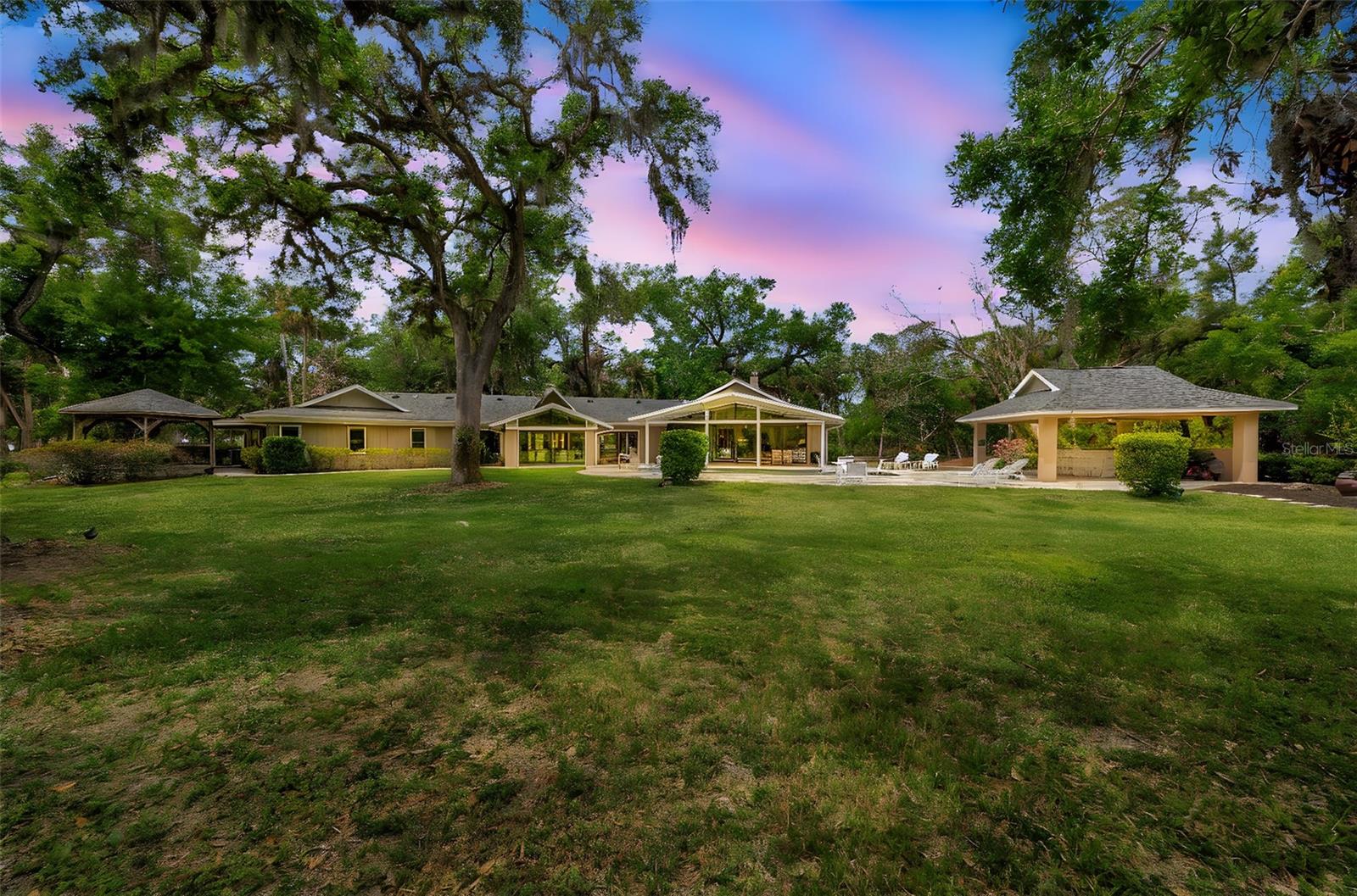 Experience the ultimate in privacy and luxury on 8.25 acres of breathtaking land in the sought after community of Fox Creek, Sarasota. This stunning estate features a 3-bedroom, 3.5-bathroom (2,716 sq.ft.) main home with an office, and 2-car garage. Plus a private 3-bedroom, 2-bath (1,404 sq.ft.) guest house with an office and carport, overlooking a tranquil pond. Surrounded by majestic grand oaks and towering palms, this property offers a gated entry, resort-style pool, expansive outdoor entertaining space, and stunning nature views.
Meticulously renovated in 2015 and 2016 by an award-winning interior designer and professional contractor, the main house showcases hurricane-impact windows and doors, elevated ceilings, and an open, spacious floor plan. The gourmet chef’s kitchen is a showstopper, featuring unique terrazzo countertops with sea glass, solid wood cabinetry, a farmhouse sink, and Monogram stainless steel appliances, including a gas range with a custom hood. Monarch European Oak flooring flows throughout the home, complementing the gas burning fireplace and interior solid-core doors. The large master suite includes an expansive walk-in closet with built-ins and an adjacent office with powder bath and access to the pool.
Designed for entertaining, the outdoor living area is complete with a rotisserie stove, icemaker, mini fridge, bar, and TV, all overlooking the updated heated pool with a pebble tech finish, sun shelf and paver deck. Additional features include a whole-house propane generator, 2016 AC’s, 2019 roof, tankless water heater, 500-gallon buried gas tank, Sonos outdoor sound system, irrigation and a whole-house security system.
The private guest house, updated in 2021, offers impact glass windows and doors, security system, upgraded kitchen and baths with granite countertops and stainless steel appliances, wood plank tile floors, recessed lighting, a glass backsplash, and a screened-in front porch with serene nature views.
This exceptional estate offers unparalleled privacy and luxury, with OUE zoning, horse's and farm animals allowed, and a low-key HOA of just $300 a year, minutes from Sarasota’s best beaches, UTC shopping and dining, Publix, Waterside and top-rated schools. Don’t miss this rare opportunity—schedule your private showing today!