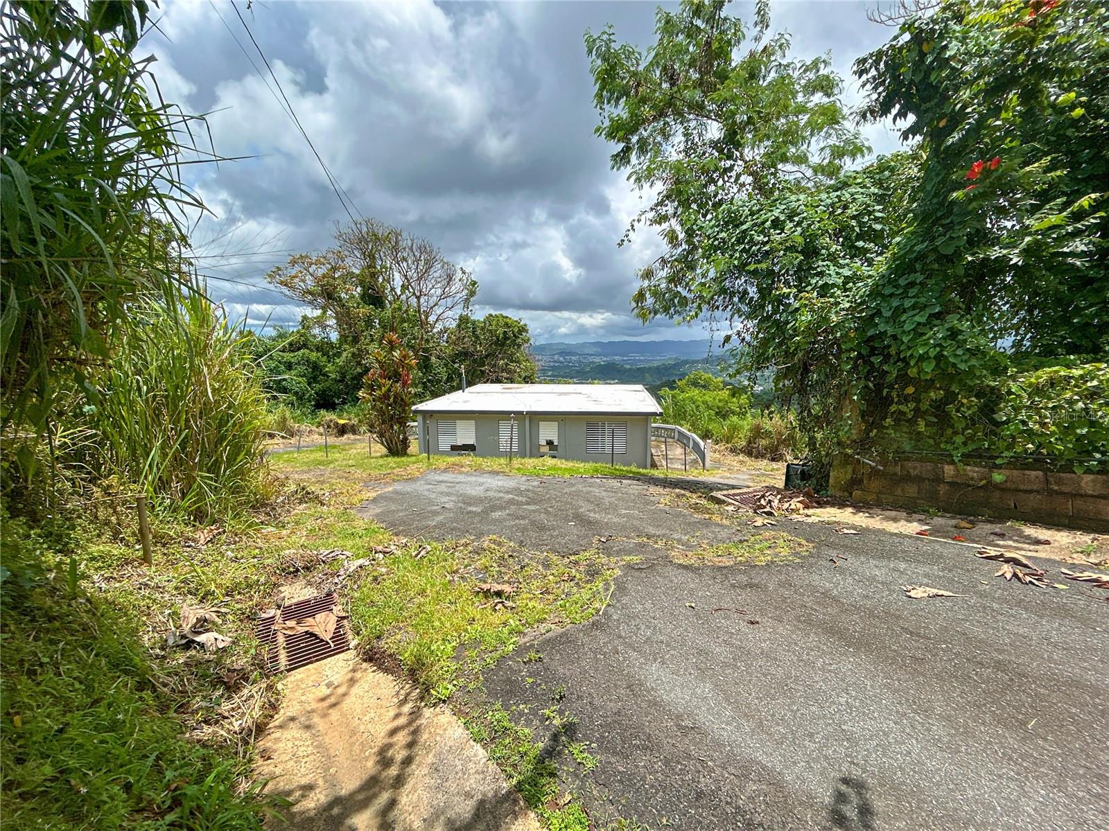 One or more photo(s) has been virtually staged. Discover a rare blend of opportunity and lifestyle in this 2.49-cuerda (9,815.87 m²) parcel in the tranquil hills of Barrio Borinquen, Caguas, Puerto Rico. Zoned RG and situated on Humatas Clay (HTF) soil, this property offers panoramic views of Caguas and PR-2 from a raised balcony and includes a charming 3-bedroom, 1.5-bath home with excellent expansion potential. Whether you're a first-time homebuyer looking to own property in a peaceful yet connected area, a second-home buyer seeking a quiet retreat with beautiful scenery, or an investor aiming to subdivide into up to four additional lots, this estate provides unmatched flexibility. Within 6 minutes (2.8 miles) of PR-1, 12 minutes (6.4 miles) to Downtown Caguas, and 22 minutes (15.2 miles) to PR-52, the location is ideal for daily commuting or weekend getaways. Nearby amenities include top schools, medical facilities, restaurants like La Cueva del Mar, and major retailers such as Sam’s Club and Home Depot — all under 20 minutes away. The fertile land, residential zoning, and elevated position make this a prime opportunity to build equity, expand your real estate portfolio, or enjoy a high-quality lifestyle in a growing metropolitan corridor.
Schedule your private showing today with Cristopher A. Hernández Bocheciamp, Lic. C-24140
Disclaimer: Property boundaries, dimensions, and adjacent parcels must be verified by the buyer through a professional land survey. All subdivision possibilities and zoning uses are subject to municipal approval and applicable land use regulations.