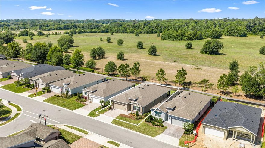 Located in the trendy resort style community of Ocala Preserve ideally positioned between I-75 and World Equestrian Center, this beautifully maintained 4-bedroom, 2-bathroom home offers approximately 2,036 sq. ft. living space on a premium lot featuring a fenced backyard and lovely pasture views! Perfect for the busy active lifestyle and the equine athlete, wanting lock and leave living. This home features upgraded curb appeal with lovely stone facade front elevation. Step inside and you’ll find a thoughtful layout offering  privacy and comfort for your guest and family while the open living, dining and kitchen area are designed for relaxed living and easy entertaining. The kitchen is wrapped in white shaker cabinetry and sleek granite countertops and highlights a large island, walk-in pantry and stainless appliances. The primary bedroom features an ensuite bathroom with double sinks, walk-in shower, water closet and two walk-in closets. The screened lanai with ceiling fans offers year round outdoor enjoyment. Additional features include gutters, window treatments, ceiling fans and an electronic patio door sun shade. Ocala Preserve is perfect for the active lifestyle with state of the art amenities, spa services, on-site restaurant, 25 miles of walking and biking trails, dog park, and golf memberships. HOA covers full lawn landscape maintenance, irrigation, gated community, internet, access to clubhouse, pools, and restaurant. Additional amenities available with a membership fee. Located minutes to WEC, HITS, Publix, Gold's Gym, Starbucks and shopping, restaurants, craft bars, cafes close by and  in Ocala’s Downtown Square and Farmers Market.  Whether you’re in the mood for a trendy dinner spot, a cozy coffee or just unwinding and listening to music, you’ll find plenty of options. ***Age restricted section, one owner must be 55+, No CDD.