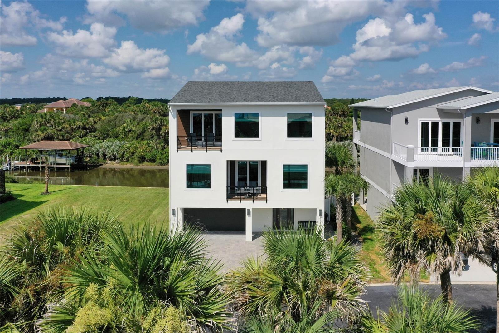 Welcome to 3538 North Ocean Shore Boulevard, a rare opportunity in Flagler County offering both deeded beach access and quick access to the Intracoastal Waterway. This beautiful three-story coastal residence, built in 2023 and offered fully furnished, blends modern comfort with the best of Florida’s waterfront lifestyle.
This move-in-ready home includes five bedrooms, four and a half bathrooms, and approximately 3,000 square feet of thoughtfully designed living space. The open-concept third floor features a well-appointed kitchen with modern appliances, a dining area, and a bright, airy living room with large windows that showcase mesmerizing ocean views. The third floor is also home to the private primary suite, complete with a soaking tub, separate shower, and dual vanities.
A private elevator provides access to all levels, making everyday living and entertaining seamless. The second floor offers three guest bedrooms, a dedicated children’s room, and a versatile flex space perfect for reading, watching a movie, or simply enjoying the views in peace.
The first floor includes a game room, a full bathroom, and a convenient kitchenette—ideal for hosting, refreshments, or rinsing off after a day at the beach. A two car garage with convenient pass-through for beach and water toys completes the layout, designed for easy access to the backyard, the water, and all your recreational needs.
Step outside to experience the serenity of Fox Cut, where you can cast a line from your own backyard with ample space to add a private dock. Just across the street, take advantage of deeded beach access for effortless walks to the sandy shoreline.
Located near private clubs with resort-style amenities, championship golf courses, a full-service marina, and scenic nature trails, this home offers a lifestyle that is both elevated and inviting. Whether you’re seeking rest or recreation, there’s something here for everyone.
With expansive water views from nearly every room, this property invites you to slow down, savor the moment, and welcome family and friends to stay awhile.
Schedule your private tour today and experience everything this exceptional coastal property has to offer.