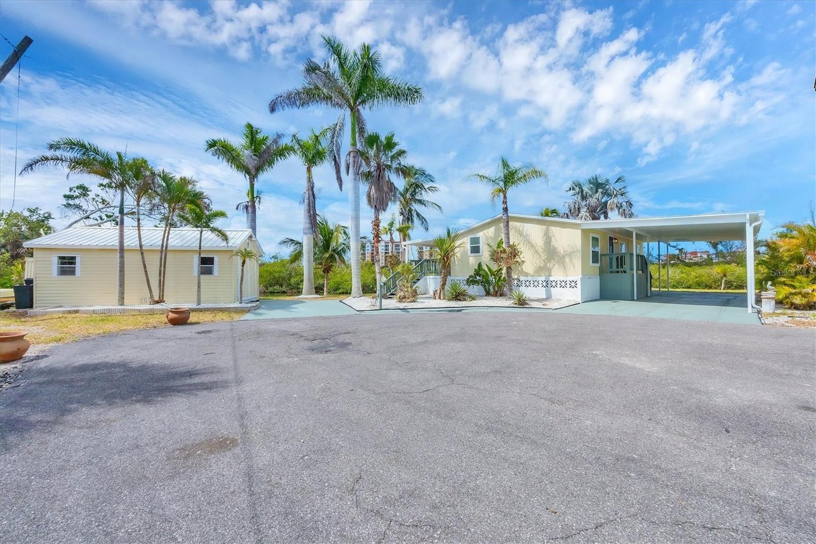 WATERFRONT, elevated home with oversized lot (.68 acres), surrounded on two sides by water. Move-in-ready Key West style paradise located just North of Venice Island on paved cul-de sac. Tropical landscaping with beautiful, mature palms creating a private, secluded sanctuary. Nestled in a desirable 55+ HOA community, this canal-front home with 185’ feet of concrete seawall offers direct boating access to the Intracoastal Waterway, allowing you to be enjoying the Gulf in 15 minutes. Property is already permitted for a boat lift and dock, transferable to new owner. Charming, historic downtown Venice is only a 10 minute walk away providing easy access to boutique stores, restaurants, the farmer’s market, fun festivals, events and a multitude of parks. Venice Beach is under 2 miles away. Outdoor enthusiasts will love having the Legacy Trail and Venetian Walkway steps from their door, offering easy access to the area's natural beauty. Imagine launching your kayak and paddling through the mangrove lined beauty of Hatchett Creek or cruising the intracoastal waterways. Don’t be surprised to see Snook, leaping Mullett, Manatee, Otters, Osprey, Herons and other wildlife from your elevated, shaded deck that runs the length of the home overlooking the water. Carport is large enough to accommodate two cars, boat or RV. Interior and exterior storage galore - including a 12x20' enclosed shed on elevated foundation with dual doors for wide entry. The immaculately renovated interior boasts a bright open kitchen with new LG stainless steel appliances, quartz countertops and Kraft-Made cabinetry. Primary bedroom adjoins a nicely remodeled bath that features a new vanity with white quartz counter and tiled walk-in shower. 2 additional bedrooms share another bath that’s new from top to bottom and has a tub for soaking. New shiplap ceilings, luxury COREtec 10 mil plank flooring, modern lighting and freshened interior/exterior paint. Updated and elevated HVAC (with 5 year parts & labor warranty), new electrical panel, and new FPL electric meter with underground wiring. You own the land, no lot rent, this home sustained no damage from the 2024 hurricane season. Your tropical paradise awaits you and your HOA approved pets.