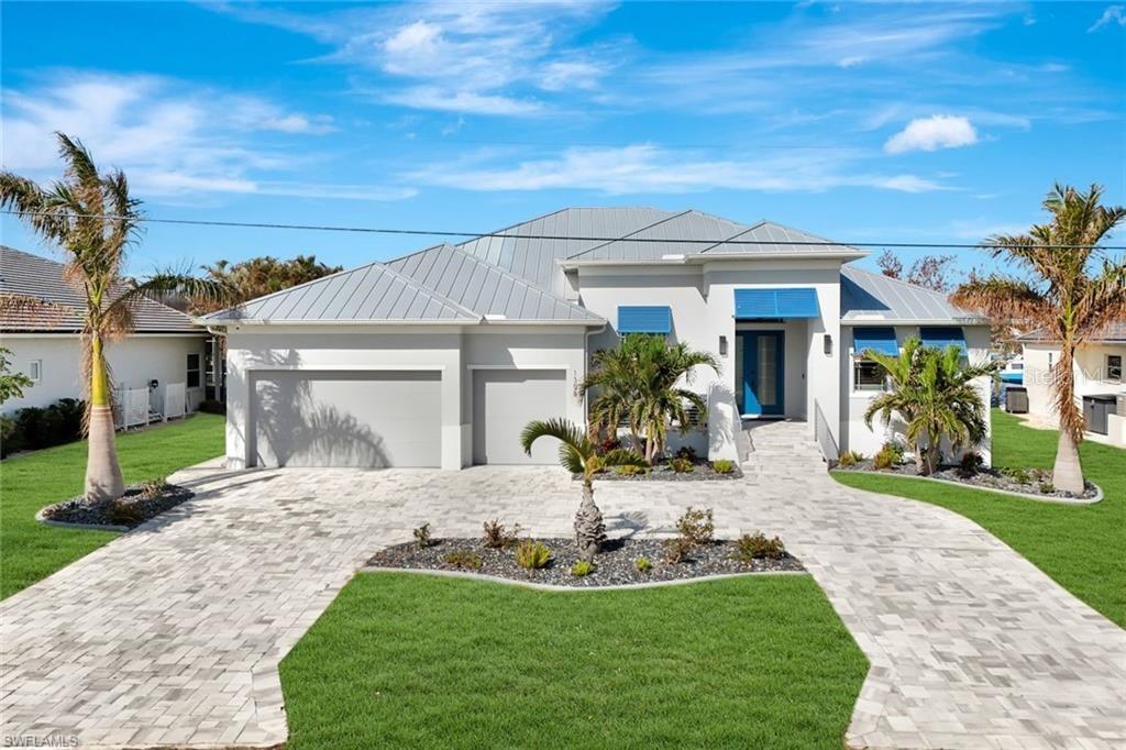 Nestled in the picturesque city of Punta Gorda, this waterfront haven offers direct Gulf access and a lifestyle of unparalleled luxury. Imagine stepping into a world where the views and outdoor spaces effortlessly blend into one stunning panorama: a saltwater pool and spa adorned with handcrafted marble pavers invites you to unwind, while an expansive outdoor kitchen sets the stage for al fresco dining under the stars. Enjoy effortless peace of mind with hurricane impact resistance windows, a remote-controlled hurricane protection screens and no-see-um screens, all while savoring the canal view. A 13,500 lb. boat lift beckons boating enthusiasts, with a boat available for purchase separately for those eager to explore the sparkling waters. Inside, discover the elegance of Thermador appliances in a kitchen that boasts a grand island, perfect for family gatherings and entertaining. Marvel at the soaring ceilings and the modern allure of porcelain tile throughout, complemented by an electric fireplace that exudes warmth and ambiance on those cool nights. The home's design features 10' zero corner pocket sliders, seamlessly blending the indoors with the outdoors. Conveniently located just minutes from downtown Punta Gorda and Fisherman's Village, with easy access to an array of amenities, and only 10 minutes by boat to the beautiful Charlotte Harbor, this property is a sanctuary of style and convenience, offering a slice of paradise tailored to your dreams.