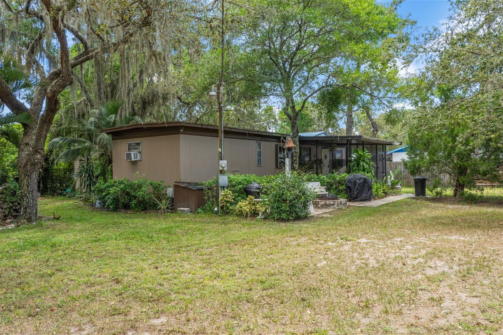 This rare double-lot property in New Port Richey offers something you don’t find every day: a potentially buildable second lot included in the sale. Whether you need extra space to spread out, or you’re dreaming of future expansion or an investment build, this property delivers unmatched flexibility—and you own both the land and the home, with no HOA and no lot rent.
Set on a fully fenced and gated parcel, the well-maintained 1-bedroom, 1-bath home includes a full RV hookup with electric and septic, three carports, and three storage sheds—providing extensive room for parking, tools, toys, or work equipment. Two gated driveways offer secure and convenient access for boats, trailers, larger vehicles, or just extra parking.
Enjoy peaceful Florida living from the screened-in porch, shaded by mature trees that provide both comfort and privacy. Inside, the home is clean, cozy, and move-in ready, with updated flooring and a functional kitchen that flows into the living area. The second room offers flexibility as a small bedroom, office, or hobby space.
Tucked into Moon Lake Estates, this location offers quick access to FL-589 Suncoast Parkway via Ridge Road, making it easy to commute into Tampa or surrounding areas. You're also close to Highway 52, local shopping, parks, libraries, and Gulf Coast recreation—including some of Florida’s best inshore fishing spots, and plenty of golf. Whether you're looking for land, independence, or a low-maintenance lifestyle with future potential, this one checks every box.