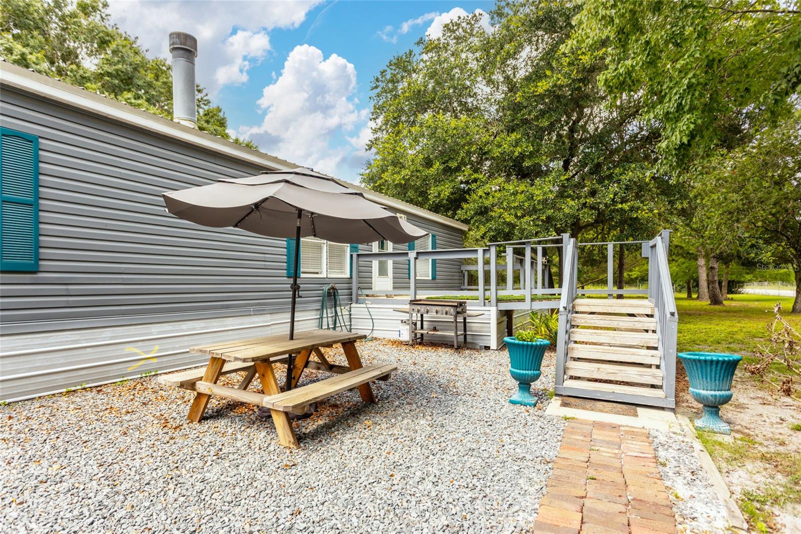 This beautifully updated 3-bedroom, 2-bath manufactured home sits on a fully fenced 0.92-acre corner lot just off of the paved road with an electric gate for added privacy and security. Inside, you'll find the home has been updated with many great features including red oak hardwood floors, a completely remodeled fireplace featuring slate and travertine stonework, and a custom tile shower in the spacious master bathroom. All bedrooms have large walk-in closets, providing ample storage and comfort. The open floor plan offers cozy living spaces, perfect for relaxing or entertaining. Outside, enjoy a chicken coop, multiple storage sheds, and plenty of room for gardening, animals, or hobbies. The well pump and sump pump are both less than a year old, offering peace of mind for new homeowners. This move-in ready property blends rural charm with modern updates—don’t miss your chance to own this unique slice of country living!