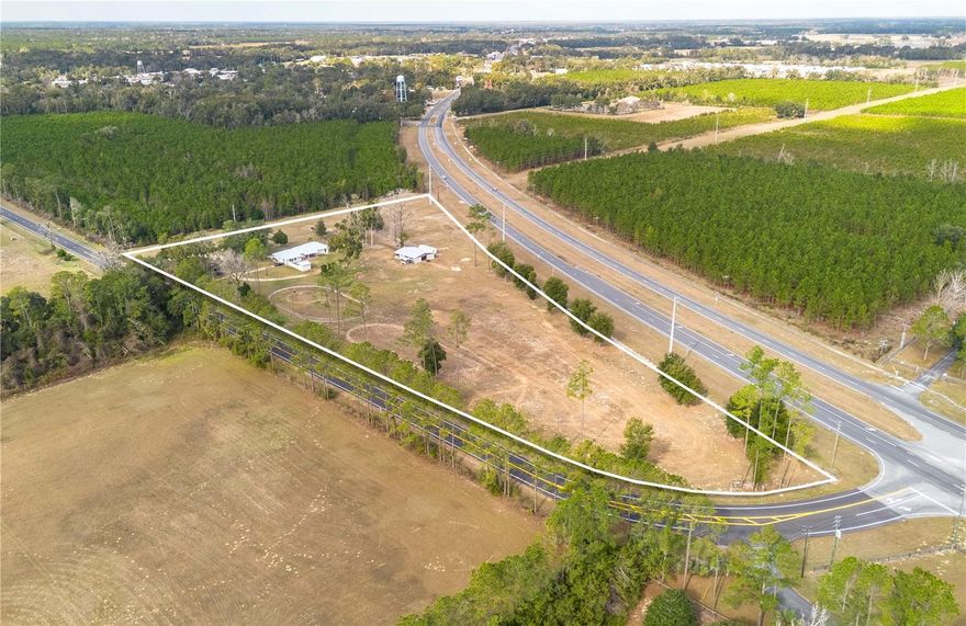 “Strategically positioned 8.76± acre C-2 zoned commercial corner in Levy County with public water onsite and multiple ingress/egress options. Oversized parcel offers flexibility for fuel/convenience development, QSR, or multi-pad commercial layout. Site size accommodates core fuel pad plus stormwater, buffers, and potential outparcel. Engineered septic feasible; sewer nearby. Existing remodeled residence and concrete barn may support interim use. Ideal opportunity for regional or national convenience retailer.”