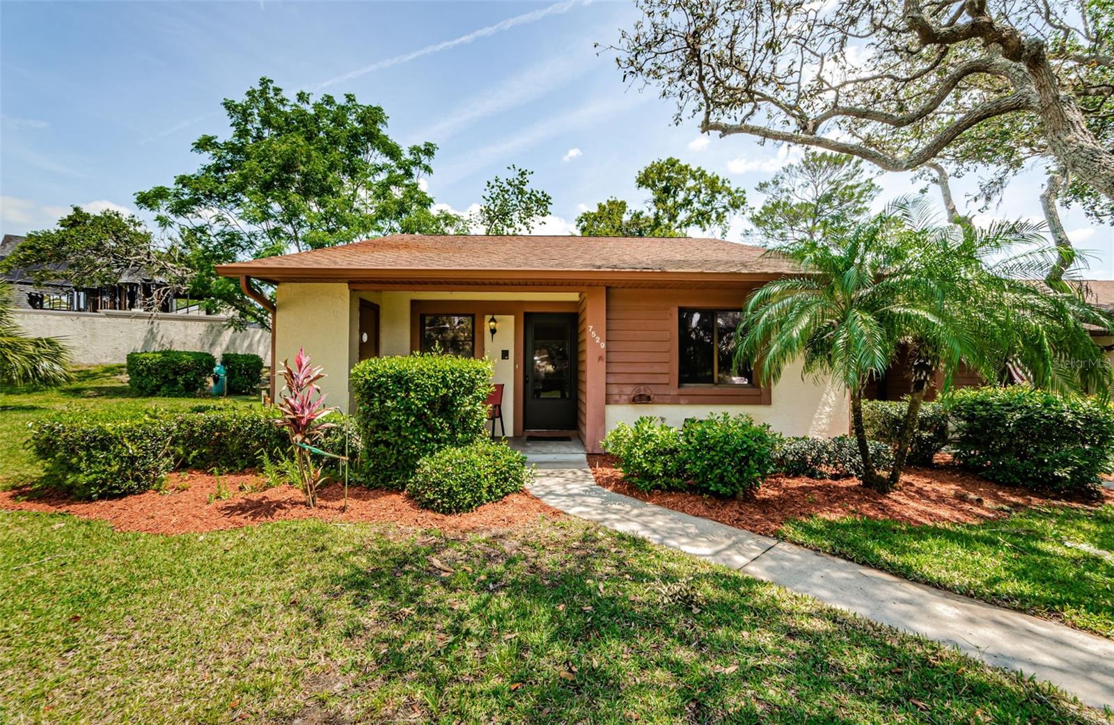 Welcome to 7529 Greystone Dr #A, an inviting end unit condo that perfectly marries comfort and convenience within a serene 55+ community. This delightful two-bedroom, two-bathroom condo spans 1,125 square feet, offering a spacious open floor plan that is both functional and charming, and reserved Carport space. The Great Room provides an ideal space for relaxation and social gatherings, seamlessly flowing into the eat-in kitchen where culinary adventures await. Step onto the warm, laminate flooring that extends throughout the home, reflecting the abundant natural light that fills every corner. The home’s thoughtful layout includes a cozy enclosed Florida room, a versatile space that could double as a serene sitting area or a peaceful retreat for hobbies, complete with a closet and full-size washer and dryer for your convenience. Stay comfortable year-round with the new air conditioning unit, just installed in April 2025, ensuring your comfort is never compromised. The property's HOA is a homeowner’s dream, including cable, internet, trash, reserves, and exterior maintenance—painting, roofing, and much more, ensuring a hassle-free lifestyle. Nestled in the esteemed Beacon Woods community, residents enjoy access to a vibrant clubhouse filled with amenities. Spend your days lounging by the heated pool, challenging friends on the tennis courts, or staying active in the fitness center. Golf enthusiasts will appreciate the nearby play-as-you-play Becon Woods golf course—a true community of fun and relaxation. Strategically located, this condo offers the perfect blend of tranquility and accessibility. Enjoy proximity to an array of shopping opportunities, medical facilities, churches, and hospitals, making every day errands effortless and leisure moments delightful. Explore the perfect setting for your golden years in this well-appointed condo, designed to cater to your every need while offering a vibrant, engaging lifestyle just outside your door. The combination of a prime location, thoughtful property features, and a wealth of community amenities makes this an exceptional and ideal blend of activity and relaxation. If you’re ready to envision your future in this vibrant community, don’t miss out on the chance to make this condo your own haven.