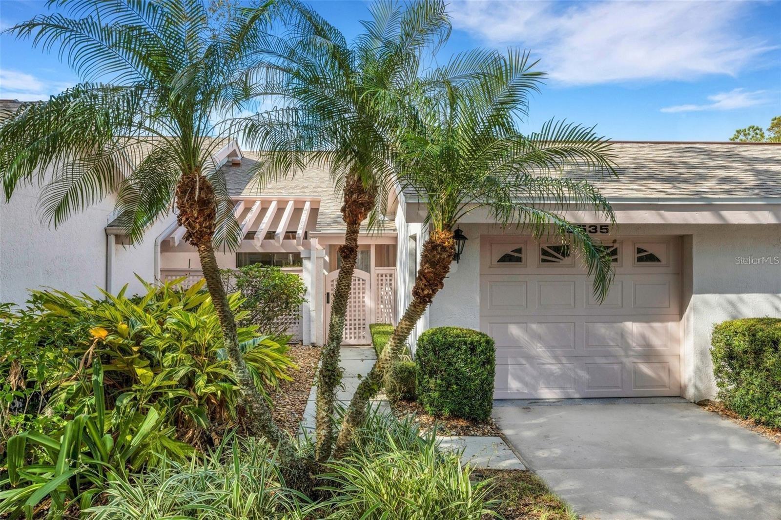 One or more photo(s) has been virtually staged. Welcome to The Meadows, one of Sarasota’s most picturesque and established golf communities! Nestled among tree-lined streets and lush landscaping, this charming 2-bedroom, 2-bathroom maintenance-free villa offers serene living in a highly desirable location, just steps from the community pool and moments from golf, dining, and downtown Sarasota. A courtyard entrance with pergola greets you with peaceful privacy, perfect for enjoying your morning coffee or tending to your favorite plants. Inside, the home features fresh paint, luxury vinyl plank flooring, and vaulted ceilings with skylights that fill the space with natural light. The open great room flows seamlessly into an enclosed lanai offering tranquil views of manicured greenery — a perfect retreat for reading or relaxing. The split floor plan provides excellent privacy, with the primary suite featuring a walk-in closet, dual vanities, and a walk-in shower. The guest bedroom and bath are thoughtfully separated, ideal for visitors or a home office. The kitchen includes a pantry with pull-out shelves and sliding doors that open to the courtyard for convenient outdoor dining. Enjoy a garage with extra storage, an indoor laundry room with utility sink, and proximity to the community pool just down the street. Recent updates include a new roof (2024), A/C (2023), and newer water heater, ensuring comfort and efficiency.
