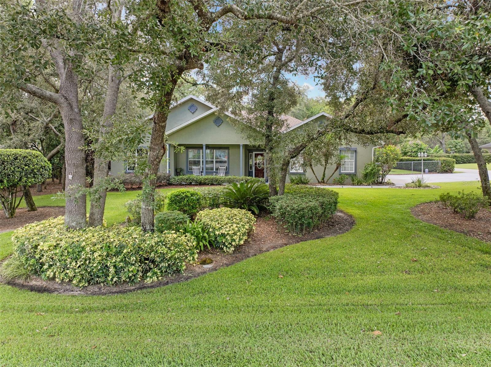IMPRESSIVE POOL HOME ON GORGEOUS CORNER LOT! Come See this spacious 2,285 sq.ft., 3 BD/2 BA home featuring the desirable floor plan that offers an open concept living area with cathedral ceiling, an attractive open kitchen and split bedroom design giving the owners’ suite quiet seclusion. Handsome luxury plank flooring begins at the foyer and continues through to the living areas and into the master suite. To the left of the foyer is the formal dining room, yet, a versatile space with wide opening leading directly to the spaciousness of the great room, kitchen that offers casual dining and seating-at-the countertop. Beautiful wood cabinets and granite counters grace the kitchen that has a walk-in pantry and stainless steel appliances. French doors by the dinette open onto the Florida room made of large windows allowing view across the screened pool/spa and beyond to the mesmerizing landscaping throughout the fenced lawn. The secluded master en suite has a spacious walk-in closet and a room that is ideal to use as an office or den; the master bathroom is outfitted with a soaking tub, large shower and a door giving access to Florida room for poolside convenience. The additional bedrooms have carpeted flooring and stand near the second full bathroom. This beautiful corner lot has stunning landscaping with outlined islands accenting oak trees, crape myrtles and ornamental plantings. The driveway to the side-positioned garage is extra wide providing a parking pad for additional autos or boat. Within the fenced backyard is a detached building that is ideal for use as a workshop or hobby cottage. This beautiful home is like Nearly New with the many updated components and features/inside and outside since 2023-2025; currently boasting a brand NEW ROOF and newer A/C, new tankless water heater, pool equipment, generator ready, newer appliances, ceiling fans and more! This impressive property is nestled within the oak hammock of the Spring Pines community(No HOA). It’s a short drive to I-4 for Orlando, Tampa, Gulf or Ocean Beaches; a convenient Central Florida location! Call today, schedule your private viewing of this beauty!