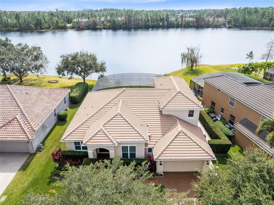 Combining nature with convenience just 8 minutes to Orlando International Airport, 2 minutes to Highway 417, 12 minutes to Lake Nona Town
Center, and walking distance to retail, this lakefront residence offers a rare blend of privacy and refined living in a quiet, gated enclave. Set along
the tranquil shores of the 33 acre Lake La Vina, the home enjoys direct water frontage and unobstructed lake views in a natural preserve setting
with frequent visits from Sandhill cranes and ducklings. The outdoor living space with southern exposure highlights the property. A triple panel of
sliding glass doors opens to approximately 1800 square feet of screened pool area with brick paver deck, ideal for dining and entertaining against
an open lake backdrop. The custom saltwater lap pool features clean architectural lines with an infinity edge toward the water, an integrated
raised spa, and a separate beach entry. Plumbing for hot and cold water is in place for a future outdoor kitchen. With wide water frontage and no
rear neighbors, the backyard offers serenity and space for canoeing, paddle boarding, or fishing directly from the property, and the canoe
conveys. Inside, the layout is expansive and intuitive, supporting both everyday living and elegant gatherings. Formal living and dining rooms
near the entry feature crown molding, architectural details, wall to wall bookcase, built in architectural niches, and abundant natural light. A
dedicated office with matching glass doors and built in storage provides a quiet workspace while remaining connected to the main living areas.
The spacious family room with tray ceiling opens fully to the screened lanai, creating seamless indoor outdoor flow. The kitchen is appointed with
42 inch wood cabinetry, stone countertops, stainless steel appliances, large center island, built in dry bar with wine storage, and additional
architectural niches that enhance the design. A bright breakfast nook overlooks the lake. The main level primary suite is designed as a private
retreat with tray ceilings, wood flooring, large windows, and direct lanai access. The en suite bath includes dual vanities, soaking tub beneath a
window, oversized walk in shower with glass enclosure, private water closet, and separate walk in closets with custom shelving. Two additional
first floor bedrooms share a Jack and Jill bath, and a pool half bath opens to the lanai. A laundry room with pedestal washer and dryer and access
to the garage with newly epoxied floor completes the main level. Upstairs features a large bonus room ideal for media or game space, an
additional bedroom with lake view, full bath, and separate utility storage room. Additional highlights include new hurricane impact windows,
resealed driveway and walkway, zoned variable speed heat pump HVAC systems, electric heat pump water heater, central vacuum, smart
irrigation controls, and tile hip roof. Located within a small gated community with park and playground, this lakefront home offers comfort,
privacy, and timeless design surrounded by nature.