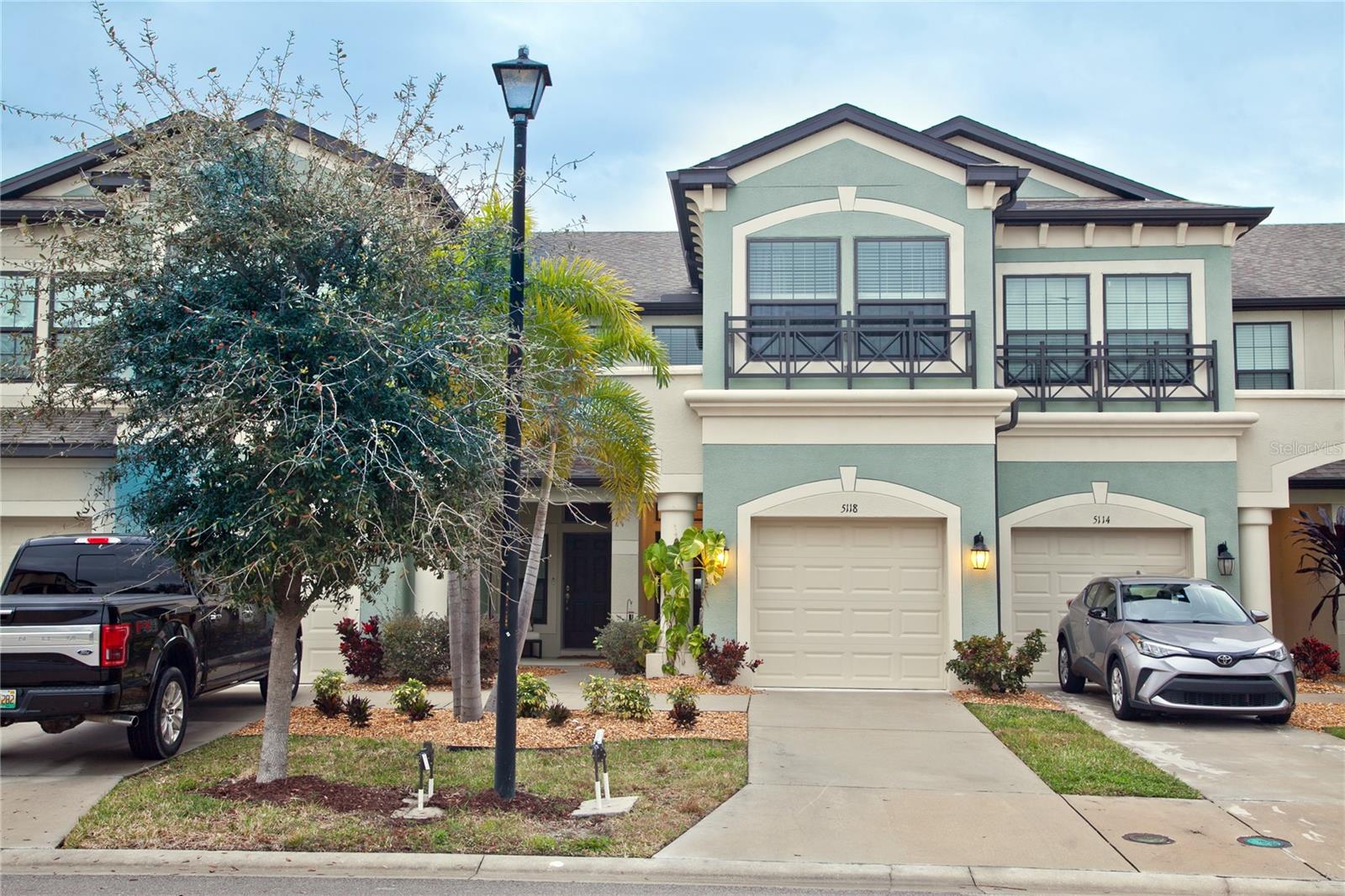 Fully upgraded townhome in the gated Creekwood community only 5 years old! The spacious open floor plan welcomes you with wood-look flooring, crown molding, noise-reduction windows, and high ceilings. The fully upgraded kitchen has GE stainless steel appliances, quartz countertops, a tile backsplash, modern cabinets, a breakfast bar, and a corner pantry. Venture out to the backyard through the sliding door in the living area and enjoy the screened patio overlooking verdant surroundings. Settle into the primary bedroom with vaulted ceilings, ample closet space, and an en suite bathroom featuring a dual sink vanity and a tiled shower with a frameless glass door. Other highlights include a sizable secondary bedroom and a bonus living area. The two-car tandem driveway and one-car garage provide ample space for your vehicles and storage needs. Creekwood Townhomes is a wonderful, gated community with NO CDDs and a LOW HOA fee, including a community pool, exterior maintenance, and pest control. You'll love the convenience of being close to The Rosedale Golf & Country Club, Publix, schools, shopping, dining, and some of the best beaches in Florida.