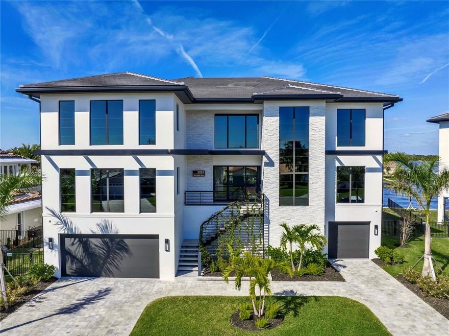 Crafted for those who demand the extraordinary. This one of a kind residence is located at the end of a private cul-de-sac in the exclusive Venetian Isles. Built by the renowned Tide Homes, Tampa Bay's premier estate builder, you'll find a sanctuary of sophistication and style. With five spacious bedrooms and five-and-a-half bathrooms, this home was designed for both entertaining and everyday living. From the moment you step through your modern oversized pivot front door, you’ll be captivated by the soaring 22-foot ceilings in the grand entryway and the stunning, handmade temperature-controlled wine cellar with a 480-bottle capacity—perfect for celebrating life’s special moments.
The heart of the home is the showstopping chef’s kitchen, featuring top-of-the-line appliances, custom cabinetry, and a massive island that’s ideal for hosting dinner parties or casual gatherings. Hidden behind a discreet door is the “messy kitchen” (butler’s pantry), complete with a separate fridge/freezer, dishwasher, sink, stone countertops, and ample storage, so you can entertain effortlessly while keeping the main kitchen pristine. Expansive impact windows and sliders flood the home with natural light and frame breathtaking views of Tampa Bay and St. Pete from nearly every room. But the true Paradise is the rooftop terrace, where you can sip your morning coffee or experience the sunset as the sky transforms into a masterpiece of color.
The third-level Flex space is an entertainer’s dream, with pocket sliding doors that open to a sprawling terrace, seamlessly blending indoor and outdoor living. This space features a striking five “cloud” ceiling design, a built-in wet bar with a wine fridge, mini fridge, custom cabinetry, recessed LED lighting, and sleek stone countertops. A dedicated stone TV wall with a floating cabinet completes the room, making it the ultimate spot to relax or host guests. The primary suite is a private retreat, enter through your French doors and find two separate custom walk-in closets, and a spa-like bathroom with separate sinks, backlit mirrors, a dedicated makeup station, a soaking tub integrated into the shower area, and a private water closet with a state-of-the-art smart toilet.
The ground level is a private oasis with an unmatched outdoor living area featuring approximately 2,000 sf of covered space showcasing level 5 ceilings, stone accents, recessed lighting, TV wall, and cabinetry.  The heated pool, hot tub, sun shelf, and fully equipped outdoor kitchen make every day feel like a vacation. Whether you’re grilling for a crowd or enjoying a quiet evening under the stars, this home was designed for effortless indoor-outdoor living. Need to work from home? A dedicated office space offers the perfect balance of comfort and productivity without having to sacrifice a bedroom. And with an elevator connecting all levels, every part of this home is easily accessible.
Located just minutes from downtown St. Pete, you’ll enjoy the best of both worlds—peaceful waterfront living and easy access to world-class dining, vibrant nightlife, and cultural hotspots. Thoughtfully designed with high-end finishes and luxurious details throughout, this home is as functional as it is beautiful. Whether you’re hosting a rooftop party, unwinding by the pool, or simply soaking in the stunning views, this home is all about living your best life. Don’t miss your chance to own one of St. Pete’s most spectacular homes—this is coastal living at its finest!