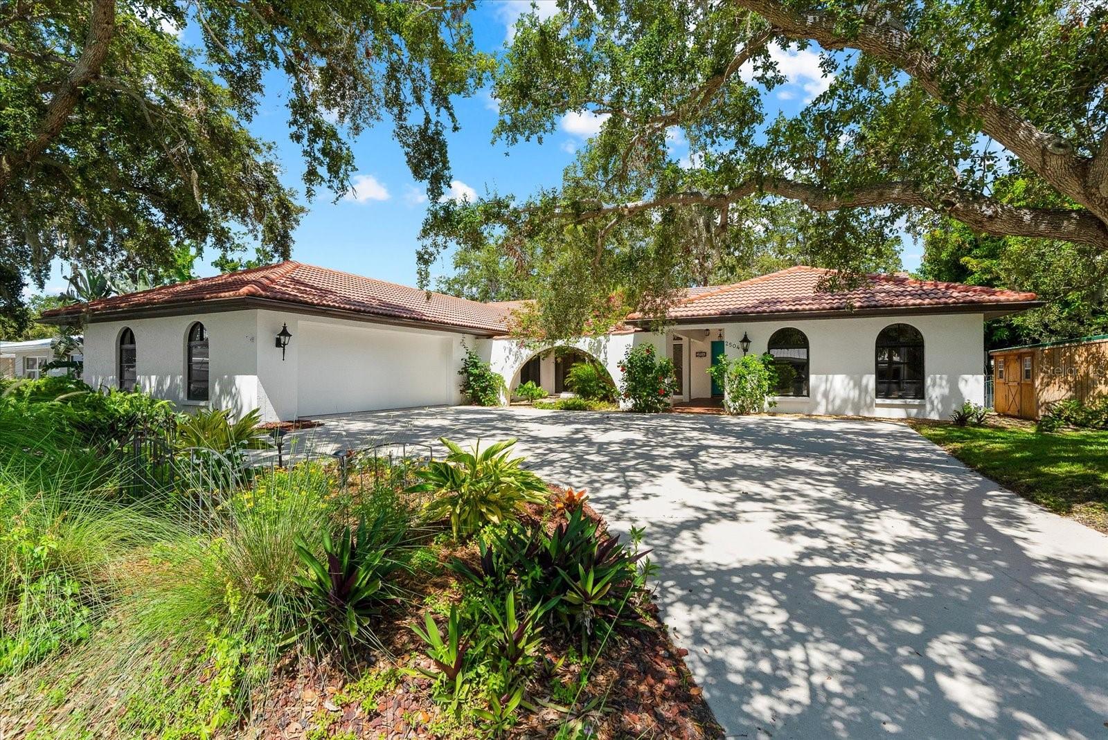 One or more photo(s) has been virtually staged. Welcome to 2504 Tanglewood Drive, a stunning Spanish-Mediterranean custom home tucked away in one of Sarasota’s most enchanting hidden-gem neighborhoods. Perched high and dry on a lush, oversized lot with 100 feet of direct frontage on picturesque Philippi Creek, this timeless residence effortlessly blends elegance, warmth, and thoughtful design — and proudly weathered last year’s storms with no damage or flooding.
From the moment you step through the private courtyard-style entry — complete with a tranquil fountain — you’ll feel the peaceful, resort-like ambiance that makes this home so special. A light-filled, gallery-style foyer sets the tone with anticipation, leading you to two distinct wings: a dramatic, oversized family room on one side and an expansive kitchen that opens to a warm, welcoming living and dining area on the other. Vaulted ceilings and a freestanding fireplace crafted from exquisite Georgia marble bring architectural drama and cozy charm, while consistent tile flooring throughout the home ensures visual harmony and easy care.
The custom kitchen is a dream for both cooks and entertainers, with granite countertops, a generous center island, abundant cabinetry, and thoughtful design details throughout. The split floorplan offers privacy and functionality, featuring a well-appointed primary suite with a spa-like ensuite bath and a large custom walk-in closet. Three large secondary bedrooms, one with its own ensuite bath, plus a third full bath, provide flexibility for family, guests, or even a home office setup. You'll also appreciate the plentiful storage and oversized 2.5-car garage with built-in cabinetry for all your tools, hobbies, or toys.
Sliding glass doors seamlessly connect the main living areas to a breathtaking, nearly 48-foot-long covered and screened lanai — where views of the creek, mature landscaping, and western skies create a private paradise. The fully fenced backyard offers towering oaks, fruit trees, a shed for extra storage, and even a whimsical treehouse with an observation deck that’s sure to delight people of all ages.
Additional features include a newer electrical panel with whole-home surge protection, and a new A/C system installed in late 2023, providing peace of mind for years to come. Owners may also choose to join the optional South Gate HOA for just $200 per year, which provides access to the South Gate Community Center — featuring a Victor Lundy designed clubhouse and community pool.
A one-of-a-kind retreat in the heart of Sarasota, 2504 Tanglewood Drive is more than a home — it’s a lifestyle. Come experience the beauty, privacy, and inspiration this waterfront haven has to offer.