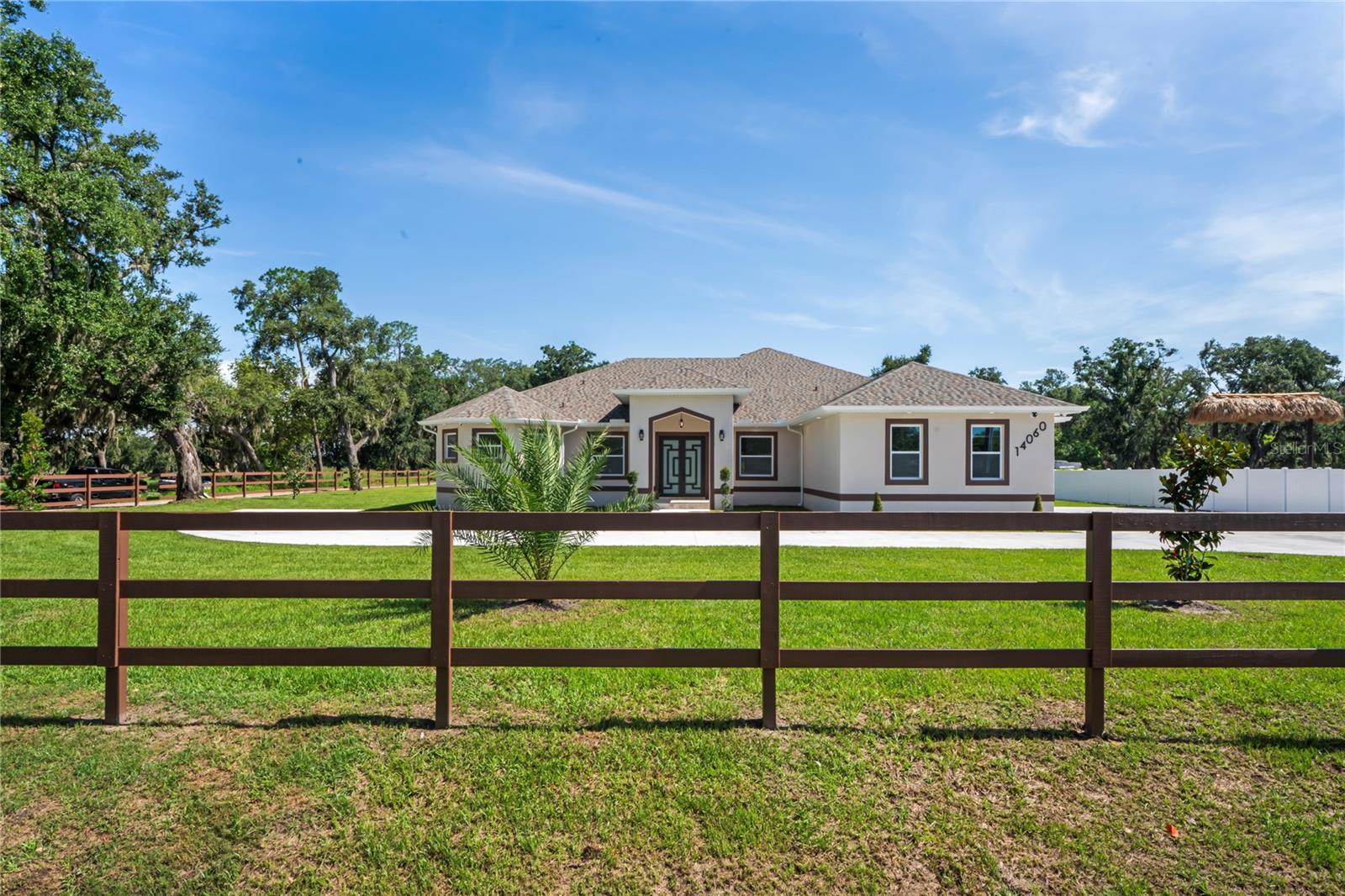 Welcome to Your Florida Home! Newly built in 2025, this stunning modern block home sits on a cleared, fully fenced 1.05-acre lot — beautifully sodded with lush grass, stately palm trees, and a few charming pines for that Florida touch.
Step inside through an impressive 9-foot dual door entryway crowned with an elegant chandelier that welcomes you into over 4,600 total square feet of refined living space — including 3,375 sq ft under air with 4 spacious bedrooms and 3.5 luxurious baths.
The expansive master suite is truly a private retreat featuring a large his-and-hers walk-in closet, a spa-like bathroom with double vanities, a soaking tub, and a stunning walkthrough triple shower. A second bedroom offers its own ensuite bathroom and walk-in closet, while two additional bedrooms share a convenient Jack-and-Jill bathroom layout — perfect for family or guests.
Designed for entertaining, the open floor plan flows seamlessly from the formal living room to a dedicated office with built-in cabinetry, and into the grand family room and gourmet kitchen. The chef’s kitchen boasts an impressive 12’ x 6’ quartz island, extensive white cabinetry, and a complete set of premium KitchenAid stainless steel appliances, including a glass cooktop and sleek range hood.
Outside, you’ll love the oversized 3-car garage and expansive wrap-around driveway, providing plenty of parking for family and guests.
This is modern Florida living at its finest — spacious, stylish, and move-in ready!