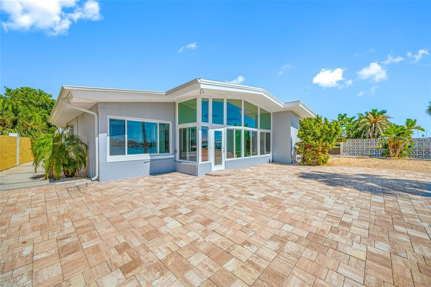 Nestled on a prime stretch of St. Pete Beach, this 3-bedroom, 3-bath Mid Century Modern waterfront residence offers 100 feet of direct water frontage with a wide southwestern exposure, ensuring stunning sunsets and expansive water vistas. A generous driveway and attached garage provide ample parking and storage, while the home’s design invites easy indoor-outdoor living. Welcoming open floor-plan and an amazing bonus Florida.Sun room with expansive view all around. Large paved waterfront patio with lots of room to entertain Family and Friends. Professionally remediated after Hurricane Helene, it’s a pristine clean canvas, ready for its new owner to personalize with their decorating vision. The property sits on a quiet cul-de-sac in coveted Bahia Shores. With no Homeowners Association, you’ll enjoy more freedom to shape the home to your taste. Monthly rentals are permitted, presenting an appealing option for investors or a flexible use plan. The home sits on a secluded cul-de-sac, enhancing serenity while still being just a short walk to the sandy shore of pristine St Pete Beach. enjoy proximity to unique restaurants, boutique shops, and waterfront amenities, with effortless access to the Pinellas Bayway, downtown St. Pete, and all the regional attractions of the Tampa Bay area. Embrace the Florida tropical beach lifestyle here, where daily sunsets over the water and a coastal breeze define modern coastal living. Make this your full time Tropical Paradise or use it as an incredible opportunity to create rental income. Come join the Florida lifestyle today.