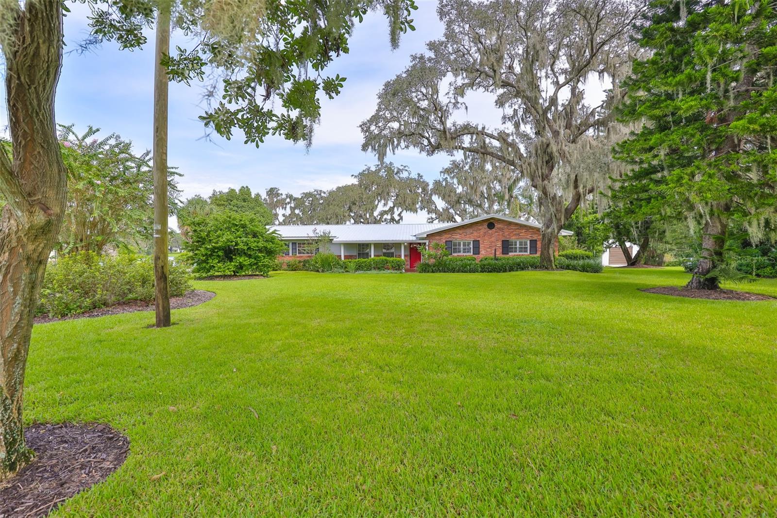 One of Dover's most breathtaking lakefront settings awaits! This Moore Lake beauty sits on a peaceful escape with lush green grass, 150' of lakeside water frontage & a 250' deep canopy of FL native plants and majestic oak trees! Life on Moore Lake means that you have the most beautiful, serene setting- where you will spot FL native birds, otters & ~16 acres of spring water right off your wood deck! Outdoor enthusiasts will love the 70' dock- perfect for boating, fishing, swimming and paddle boarding. At the end of the dock, a 10'x10' sunning platform is complete with electricity and a water spigot. Built in 1959, this home has been lovingly maintained by ONE family! Step inside to find a 1819 SF, one story block home ready to move in or customize to your taste! Features include: oversized picture windows in the family room, terrazzo & parquet flooring, oversized bedrooms, shutters + a 20'x10' screened/covered lanai retreat off of the dining room's French doors. The kitchen upgrade is a showstopper: quality Forevermark wood cabinetry with dovetail & soft close drawers, sliding shelves, upper cabinets extended to the ceiling, crown molding, black cabinet hardware ++ a custom cabinet pantry! Under mounted lighting, glass mosaic tile backsplash, Shaw's Farmhouse single basin apron front sink, stainless steel appliances, quartz countertops & a white shiplap ceiling complete the space! Need room to tinker? There's plenty of options here: 24'x24' 2 car detached garage, 23'x11' 1 car attached garage (has a shower!) or a 30'x12' work shed with electricity and 6.5'x 8' double doors. Utilities include: well water with Culligan Clean Water home softener and AC30 Reverse Osmosis, septic tank and lake water for lawn irrigation! Bonus features include: 2021 silver metal roof (home and garage) with gutters. No past flooding here! No flood insurance required! Hurricane shutters available for select windows & the shed is strapped down. If you're looking for a peaceful escape with a touch of rural charm, unincorporated Dover delivers. Blackjack Rd is a quiet 16 home street with 1+ acre parcels (zoned ASC-1), no HOA, no big communities, no compromise on tranquility! Drive commutes approx: 3.3 mi to Interstate 4, 25 min to Channelside (downtown) Tampa, 35 min to MacDill AFB, under 1 hr to St Pete Beach or Disney Springs! School distance: 1.5mi Elem School, 1.5 mi High School, 5.4 mi to Middle School. CHECK OUT ZILLOW SHOWCASE, 3D TOUR AND FLOORPLAN!